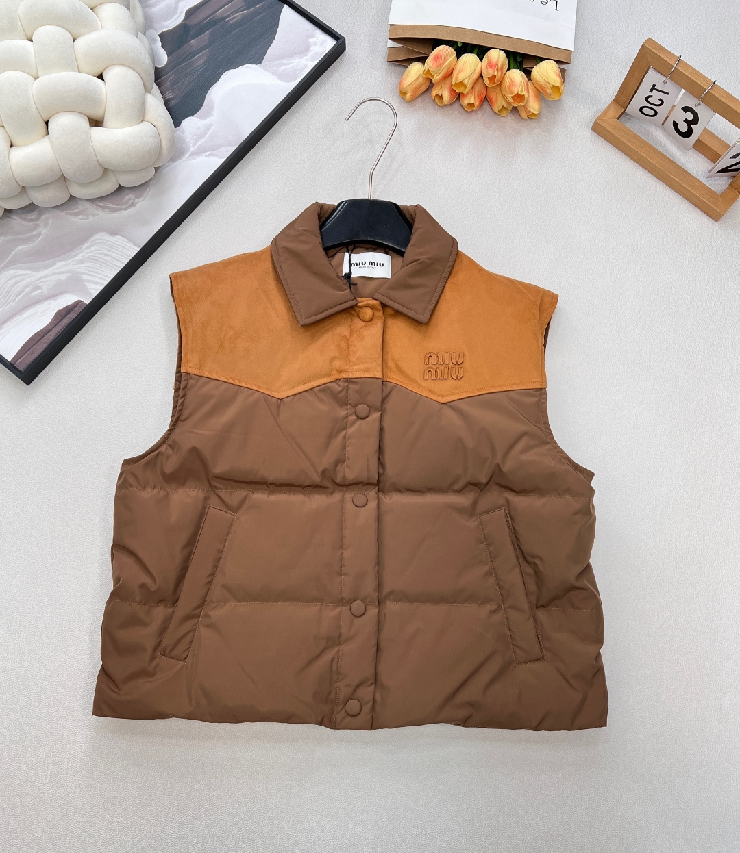 NO:608009,Comes with dust bag MiuMiu25FW new autumn and winter leather logo lapel stitching contrasting down vest丨Exclusive high-end version!  The core design is leather splicing + letter logo. The collar/shoulder area is made of caramel brown suede-like leather, which collides with the main milk tea apricot nylon fabric. It comes with a retro lazy filter; 90 white goose down filling  , with high fluffiness but no weight-bearing feeling, taking into account the cold weather in autumn and winter and the flexibility of daily wear. The lapel version is suitable for layering, the single-row button opening and closing is easy to put on and take off, and the quilted and down-filled technology keeps you warm without looking bulky; the two colors are outstanding  Size sml code,,miumiu,down jacket,chamois leather,alexander wang19860909配防尘袋 MiuMiu25FW秋冬新款皮革徽标翻领拼接撞色羽绒马甲丨独家高版出品！以皮革拼接+字母徽标为核心设计,领口/肩背区域采用焦糖棕麂皮质感皮革,与主体奶茶杏尼龙面料碰撞,自带复古慵懒滤镜；90白鹅绒填充,蓬松度高却无负重感,兼顾秋冬御寒与日常穿搭的灵动感.翻领版型适配叠穿,单排纽扣开合方便穿脱,绗缝充绒工艺既保暖又不显臃肿；两色出 尺码sml 编码,,miumiu,down jacket,chamois leather,alexander wang,Women's clothing