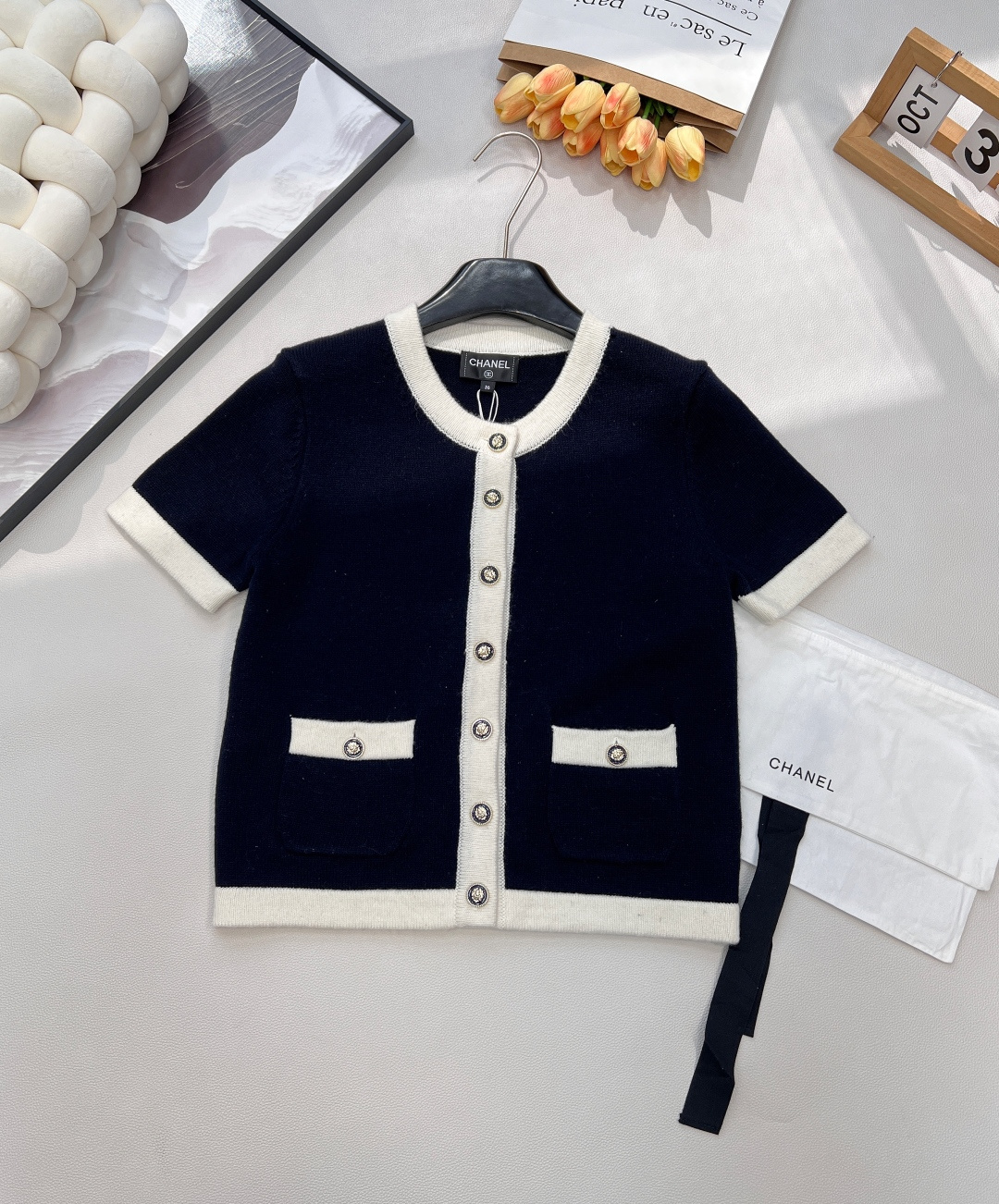 NO:610545,Chanel2025 New Contrast Color Round Neck Knitted Short Sleeves, Customized YB Cashmere Yarn Weaving, Density Fine Knitting, Soft and Waxy Texture, Comfortable and Skin-Friendly, Round Neck Buttons, Front Shoulder Short Sleeve Cardigan Cut, Large Front Round Button Camellia Dress  points, reflecting the light, giving a simple and relaxed feel. It is matched with the contrasting color of the hemming extending from the collar and front to the hem and cuffs, echoing the edges of the pockets, enriching the design layering, the version is tolerant of the figure, and the outfit is full of temperament. Comes with an exquisite lace-up dust bag  Customized surface accessories, complete three standards, large shipments, size sml code, chanel, T-shirt, alexander wang19860909Chanel2025新款撞色包边圆领针织短袖,定制YB羊绒纱线织造,密度细针织造,软糯质地,舒适亲肤,圆领纽扣正肩短袖开衫剪裁,大身前襟圆扣山茶花装点,折射出光线,穿出简约松弛感,配合领边前襟延伸至下摆袖口的包边撞色,与口袋边缘呼应,丰富设计层次感,版型包容身材,穿搭气质十足.配有精致系带防尘袋 定制面辅料 三标齐全,大货出 尺码sml 编码,,chanel,T-shirt,alexander wang,Women's clothing