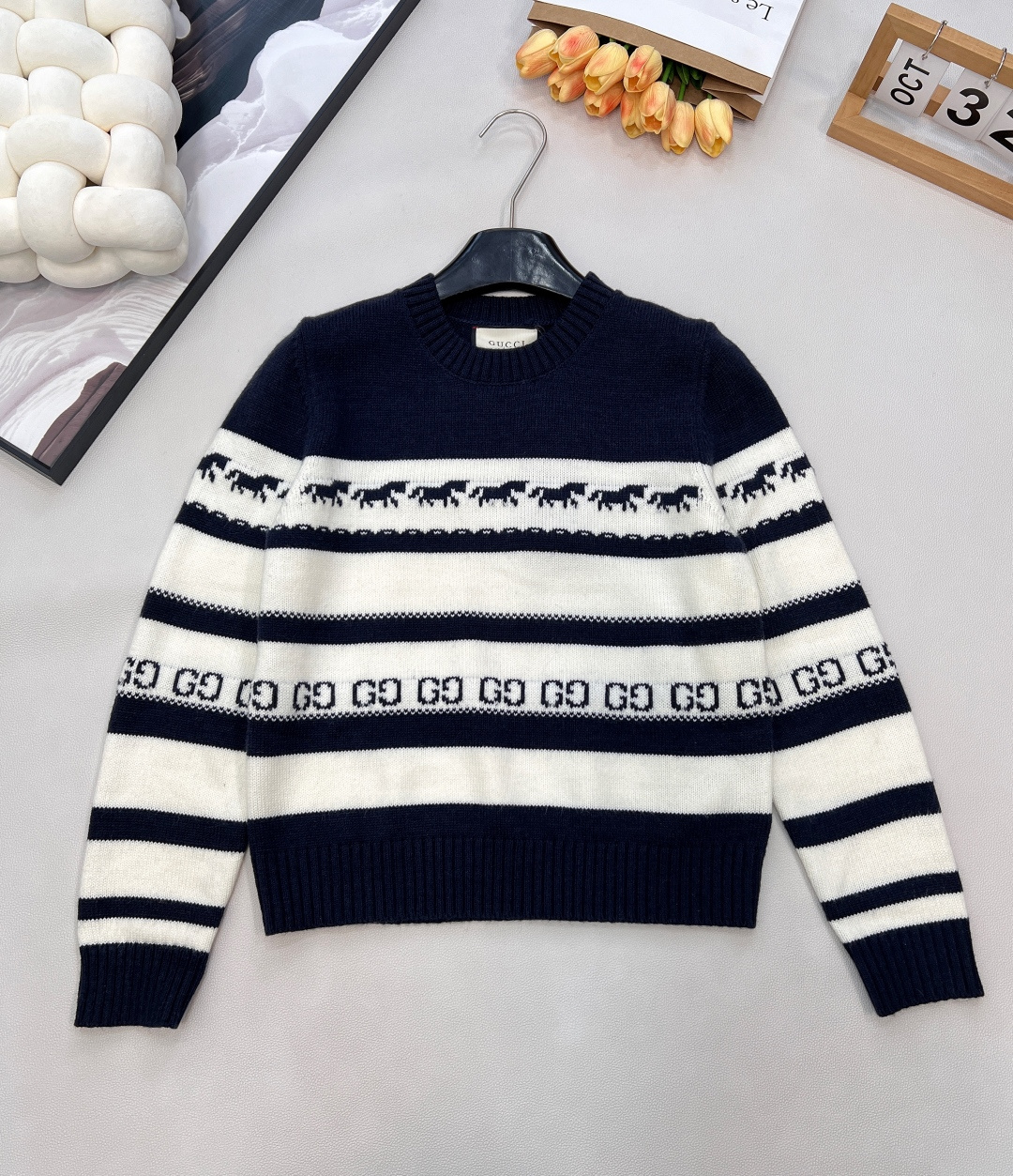 NO:621674,GUCCI2025 new knitted round neck long sleeves, the clever fusion of all-over pony jacquard and double G dark pattern, full of interest and recognition. Fine knitted texture, soft and waxy next to the skin, more drapey, every touch is a luxury of texture. Navy + white color matching,  It is a classic retro tone accumulated by time. The pony jacquard all over is smart and playful, and the double G dark pattern is low-key to highlight the brand recognition. It is easy to control the retro style. Whether it is paired with denim denim or a plaid skirt, it can create a lazy and high-end retro atmosphere.  The red + white color scheme is a vivid expression of vitality. The pony jacquard jumps between red and white contrasting colors, and the double G dark pattern hides the design ingenuity. It instantly grabs the visual focus and injects a bright color into autumn and winter outfits. Whether it is paired with black leather pants to create a cool style, or paired with a skirt of the same color to create a sweet and spicy look, it can make you stand out from the crowd.  Two colors, two styles, but also full of fashion attitude. Gucci's knitted round neck long sleeves, with exquisite craftsmanship and creative design, will help you find your own dressing rhythm between retro and fresh. This autumn and winter, it will be fun and recognizable, and become a fashion ace in your wardrobe. Complete with three labels, large quantities are available. Sizes sml code G,, gucci, gucci, skirts, alexander wang19860909GUCCI2025新款针织圆领长袖,满幅小马提花与双G暗纹的巧妙融合,将趣味与辨识度拉满.细密针织纹理,贴肤软糯更具垂感,每一次触碰都是质感的奢享.藏青+白配色,是时光沉淀下的经典复古腔调,满幅小马提花灵动俏皮,双G暗纹低调彰显品牌辨识度,轻松驾驭复古风穿搭,无论是搭配牛仔单宁还是格纹半裙,都能演绎出慵懒高级的复古氛围感. 红+白配色,是活力迸发的鲜活表达,小马提花在红白撞色间跃动,双G暗纹暗藏设计巧思,瞬间抓住视觉焦点,为秋冬穿搭注入一抹亮色,不管是搭配黑色皮裤打造酷飒风格,还是与同色系半裙营造甜辣感,都能让你在人群中脱颖而出. 两款配色,两种风格,却同样拥有满格的时尚态度,古驰这款针织圆领长袖,以精湛工艺与创意设计,带你在复古与鲜活之间,找到属于自己的穿搭节奏,这个秋冬,让趣味与辨识度并存的它,成为你衣橱里的时尚王牌.三标齐全,大货出 尺码sml 编码G,,gucci,gucci,skirts,alexander wang,Women's clothing