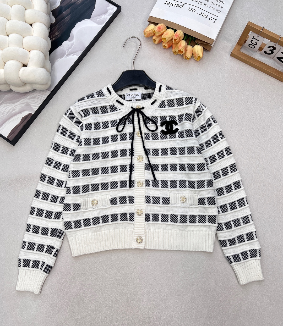 NO:621670,CHANEL25 new knitted round-neck cardigan, twin plaids, unbounded sophistication in style  When classic black and white meets sweet pink and white, the contrasting drawstring design on the neckline (black/pink interweaving) is full of cleverness and ingenuity in every rope and knot. The three-dimensional double C logo on the chest is a classic statement of the brand's genes and is highly recognizable. The pockets and buttons are embedded with small diamond buttons. Every time you raise your hand and insert your pocket, there are tiny pieces of light flowing, pushing the sophistication to the full level.  Using plaid + vertical stripe splicing weaving method, the two textures collide to create a rich sense of layering, making knitting no longer monotonous. It has its own visual focus and tactile texture. Whether it is worn with jeans for a casual French style, or with a skirt to demonstrate the elegance of a socialite, it can be accurately adapted and becomes the 'exquisite anchor' in the style.  The classic black and white grid is a timeless tone; the sweet pink and white grid is the embodiment of girlish tenderness - one cardigan, two styles, covering all your dressing imagination. In the fashion context of 2025, with Xiaoxiang style and exquisiteness, define your style label. Three standards are complete, two colors are outstanding. Size sml code H,,chanel,skirts,jeans,alexander wang19860909CHANEL25新款针织圆领开衫,格纹双生,风格无界的精致主义 当经典黑白邂逅甜嫩粉白,领口撞色抽绳设计（黑/粉交织）,一绳一结间尽是灵动巧思；胸前立体双C标,是品牌基因的经典昭示,辨识度拉满.口袋与纽扣嵌满小钻扣,每一次抬手、每一回插兜,都有细碎光芒流转,将精致度推至满格. 采用格纹+竖条拼接织法,两种肌理碰撞出丰富层次感,让针织不再单调,自带视觉焦点与触觉质感,无论是搭配牛仔裤走随性法式风,还是配半裙演绎名媛优雅感,都能精准适配,成为造型里的“精致锚点”. 经典黑白格,是永不过时的腔调担当；甜嫩粉白格,是少女感的温柔具象——一件开衫,两种风格,承包你所有穿搭想象,在2025的时尚语境里,以小香式精致,定义属于你的风格标签.三标齐全,两色出 尺码sml 编码H,,chanel,skirts,jeans,alexander wang,Women's clothing