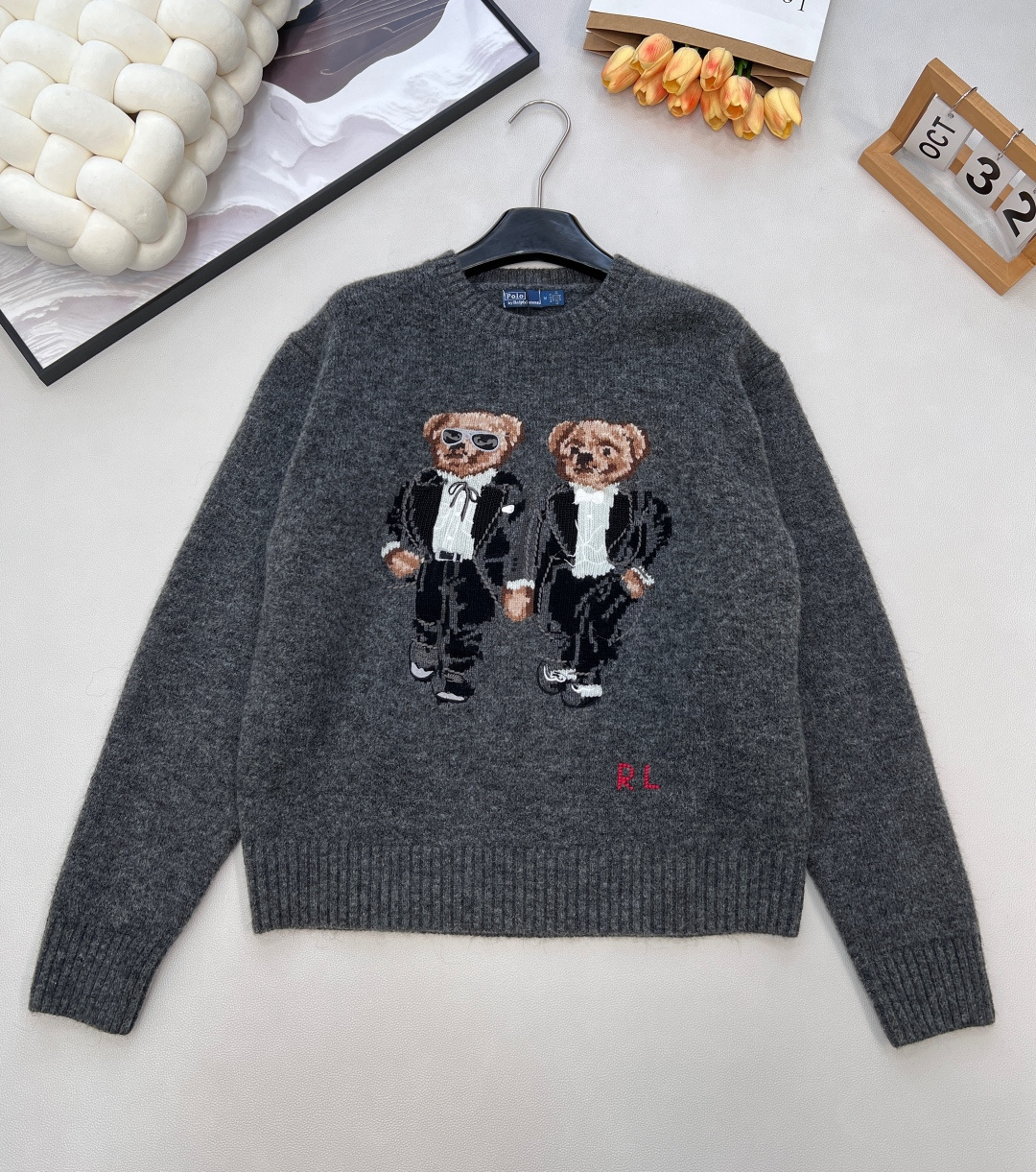 NO:623423,Ralph Lauren's new bear sweater, when classic American luxury meets cute design, Ralph Lauren's bear long-sleeved sweater has become the 'texture trump card' of the winter wardrobe.  Selected wool knitted fabrics, with high-end gray as the background color, have a low-key and luxurious atmosphere. The image of the two bears in black suits on the chest is particularly eye-catching - one wears sunglasses, cool and uninhibited; the other is elegant and calm, perfectly blending the American retro gentleman style with childlike ingenuity. Each stitch texture demonstrates the brand's ultimate pursuit of details. The red 'RL' logo in the lower right corner is the iconic identity mark of Ralph Lauren.  The round-neck style is versatile and unobtrusive, and the loose tailoring combines comfort and style. Whether worn with a shirt to create a sense of hierarchy or worn alone to highlight your personality, it can easily hold various styles. From urban commuting to casual outings, it is not only a warm tool, but also a fashion symbol that shows your taste. It allows you to stand out in the dull winter with a touch of cuteness and sophistication. Three standards are complete, and large quantities are shipped. Sizes sml code R,, loro piana, shirts, business suit, alexander  wang19860909Ralph Lauren新款小熊针织衫,当经典美式奢华邂逅萌趣设计,拉夫劳伦这款小熊长袖针织衫便成了冬日衣橱的“质感王牌”. 精选羊毛针织面料,以高级灰为底色,自带低调奢华的氛围感.胸前两只身着黑色西装的小熊形象尤为吸睛——一只佩戴墨镜,酷飒不羁；一只优雅从容,将美式复古的绅士格调与童趣巧思融合得恰到好处,每一针纹理都彰显品牌对细节的极致追求.右下角红色“RL”标识点睛,是拉夫劳伦标志性的身份印记. 圆领版型百搭不挑人,宽松的剪裁兼顾舒适与造型感,无论是内搭衬衫打造层次感,还是单穿凸显个性,都能轻松hold住各种风格.从都市通勤到休闲出街,它既是保暖利器,更是彰显品味的时尚符号,让你在冬日的沉闷里,凭一抹萌趣与精致脱颖而出.三标齐全,大货出 尺码sml 编码R,,loro piana,shirts,business suit,alexander wang,Women's clothing