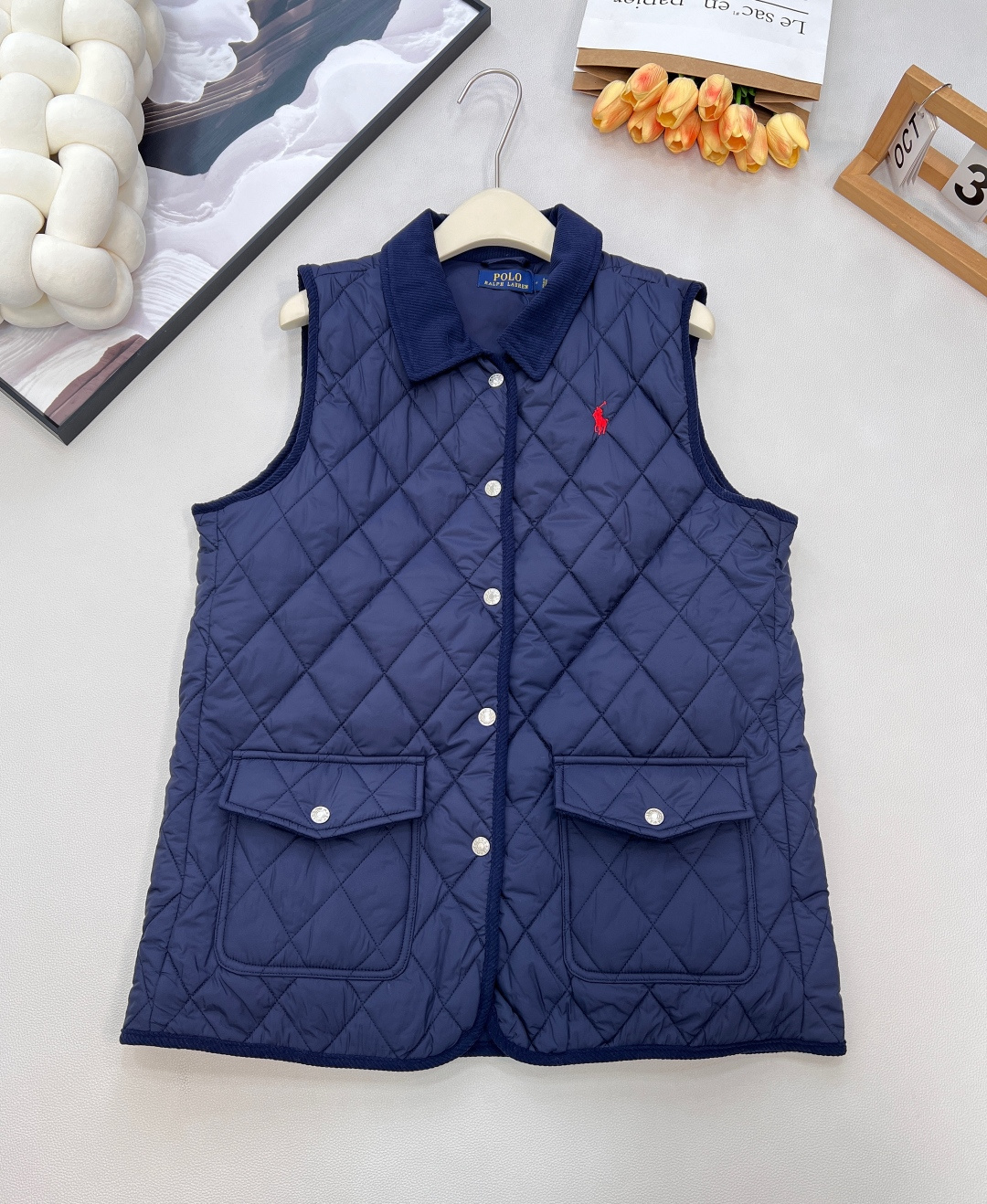 NO:624152,Ralph Lauren's new corduroy-trimmed quilted vest is a classic American relaxed early-autumn 'atmosphere artifact' with retro details and environmentally friendly textures. It is a versatile ace in the layering season. 'Retro contrasting colors, texture is in the details' - Corduroy-trimmed wide-angle lapels, plackets, armholes, pocket edges and hems are all spliced with corduroy. It has a warm-toned texture with a retro filter, making it easy to adapt to layering scenes such as jeans and shirts; -  The iconic logo is embroidered with a classic pony logo on the left side of the chest, showing brand recognition in a low-key manner; - Practical design snap-button placket + double snap-button patch pockets at the waist, a sleeveless silhouette that is neat and not bulky, and side panels to increase room for movement. Lightly padded diamond-shaped quilting is both warm and lightweight without weighing down the body; the entire piece is made of recycled polyester fiber (fabric + filling), which retains a crisp texture while practicing the concept of sustainable fashion.  Three soft colors are available (white/khaki/navy), suitable for commuting, leisure and other various occasions. It is a 'simple but not simple' texture item in the early autumn wardrobe. Complete with three standards, large quantities are shipped. Size sml code R,, loro piana, shirts, alexander wang19860909Ralph Lauren 新款灯芯绒饰边绗缝马甲,经典美式松弛感的早秋“氛围感神器”,复古细节碰撞环保质感,是叠穿季的百搭王牌. 「复古撞色,细节见质感」 - 灯芯绒饰边宽角翻领、门襟、袖孔、口袋边缘与下摆均以灯芯绒拼接,自带复古滤镜的暖调质感,轻松适配牛仔、衬衫等叠穿场景； - 标志性标识胸前左侧绣有经典小马标,低调中透出品牌辨识度； - 实用设计按扣式门襟+腰部双按扣贴袋,无袖廓形利落不臃肿,侧边镶片增加活动余量.轻度填充的菱形绗缝,兼顾保暖与轻盈不压身；全件采用再生聚酯纤维（面料+填充物）,在保留挺括质感的同时,践行可持续时尚理念. 三色可选的柔和色系（白/卡其/藏青）,适配通勤、休闲等多元场合,是早秋衣橱里“简约不简单”的质感单品.三标齐全,大货出 尺码sml 编码R,,loro piana,shirts,alexander wang,Women's clothing