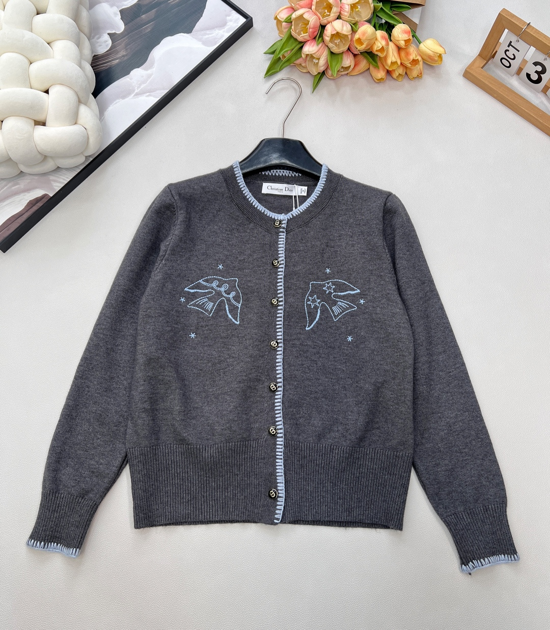 NO:629417,DIOR's new peace dove embroidered knitted cardigan has a lazy and refined feel - The soft dark gray knitted textured fabric is soft but not collapsed, it is comfortable against the skin and can keep warm, so it is not burdensome for daily wear. - Highlights of the details: The collar, placket, and cuffs are all made of light blue contrasting raw edges, plus the peace dove + star embroidery on the chest, which is fresh and recognizable; the metal buttons have the Dior logo, which is low-key and luxurious. -  Suitable to wear with a shirt + trousers for commuting, with suspenders + jeans for a relaxed everyday style. A cardigan is suitable for outer wear or inner wear. Three standards are complete, large quantities are shipped, size sml code, dior, dior, shirts, alexander wang19860909DIOR新款和平鸽刺绣针织开衫,自带慵懒精致感 - 质感面料柔和的深灰色针织,触感软而不塌,贴肤舒适还能兼顾保暖,日常穿完全没负担. - 细节亮点领口、门襟、袖口都做了浅蓝撞色毛边,加上胸前的和平鸽+星星刺绣,清新又有辨识度；金属纽扣带迪奥标识,低调透出轻奢质感. - 穿搭适配搭衬衫+西裤是通勤精致挂,配吊带+牛仔就是松弛日常风,开衫外穿或内搭都适配.三标齐全,大货出 尺码sml 编码,,dior,dior,shirts,alexander wang,Women's clothing