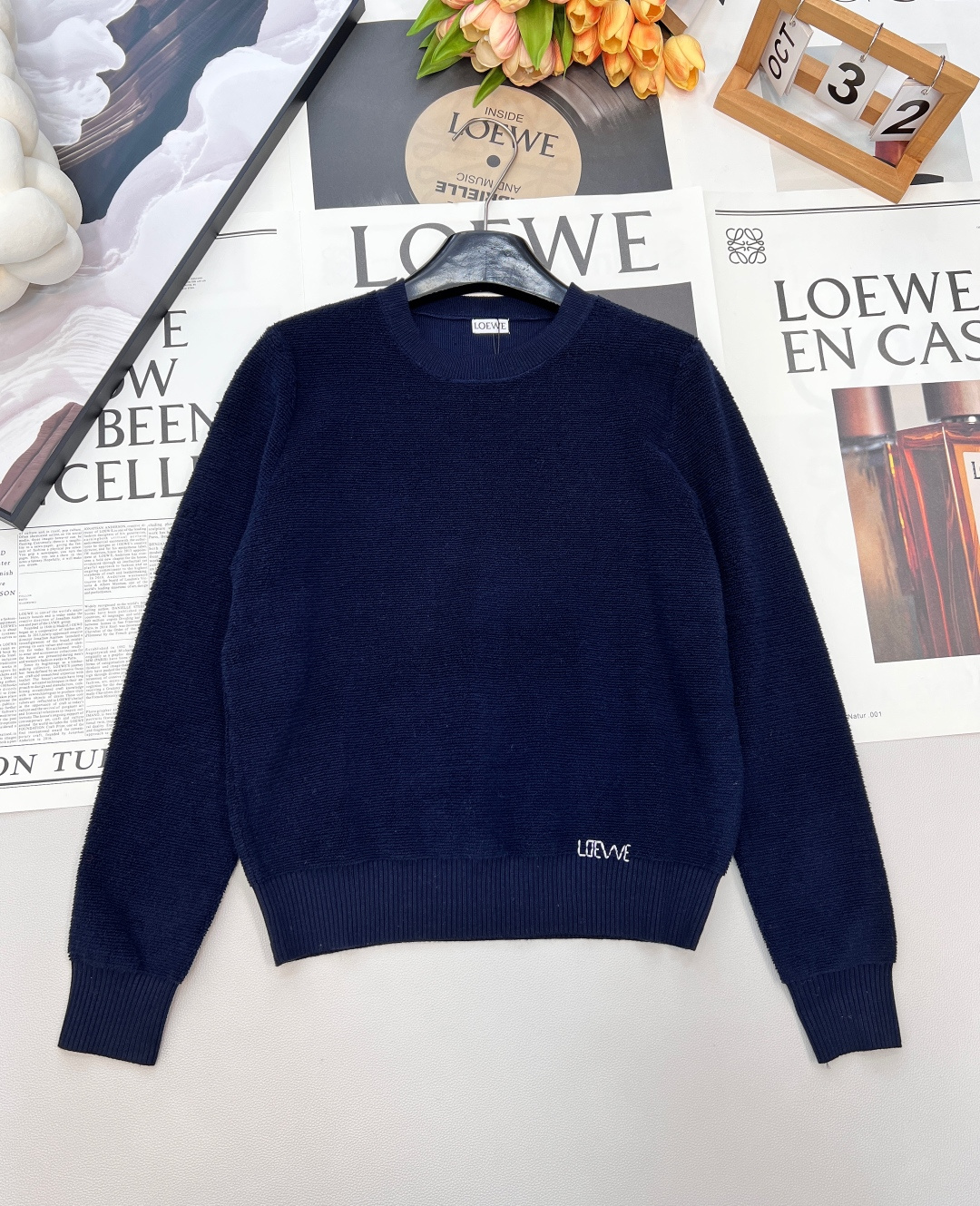 NO:655121,Loewe's new letter-embroidered sweater brings 'elegant relaxation' to the body. The round neck + embroidered logo = the 'universal card' for the autumn and winter wardrobe. The simple and basic style has the most texture - the gentle round neck is suitable for various inner and outer wear. The slightly loose version hides the flesh and stretches, and it is effortless elegance when raising your hands.  The textured knitted fabric on the surface has a delicate luster and feels soft against the skin like a layer of clouds; the mini embroidered logo on the hem is low-key and discreet, delicate and unobtrusive, and makes you look noble at a glance. The two colors have their own atmosphere - the milky white is gentle and can be worn with a skirt to look like a wealthy daughter, and paired with jeans can be a relaxed commute - navy blue is the 'king of slimming' in autumn and winter, and it is high-end when worn with a layered coat or worn alone with boots.  Two colors and three sizes are available in seconds. Whether it is daily commuting or light dating, you will win in quality when you put it on ~ complete three standards, two colors, size sml code, loewe, boots, skirts, jeans, alexander wang19860909Loewe新款字母刺绣针织衫,把“优雅松弛感”穿在身上,圆领+刺绣Logo=秋冬衣橱的“万能牌” 简约基础款最见质感——温柔圆领适配各种内搭外穿,微微宽松的版型藏肉又舒展,抬手间都是不费力的优雅. 表面的肌理针织自带细腻光泽,贴肤软乎乎的像裹了层云朵；下摆的迷你刺绣Logo是低调小心机,精致不张扬,一眼就显贵. 两色各有氛围 - 奶白色温柔挂天菜,搭半裙是富家千金,配牛仔裤是松弛通勤 - 藏青色秋冬里的“显瘦王者”,叠穿大衣/单穿配靴都高级 二色三码现货秒发,不管是日常通勤还是轻约会,套上就赢在质感~三标齐全,两色出 尺码sml 编码,,loewe,boots,skirts,jeans,alexander wang,Women's clothing