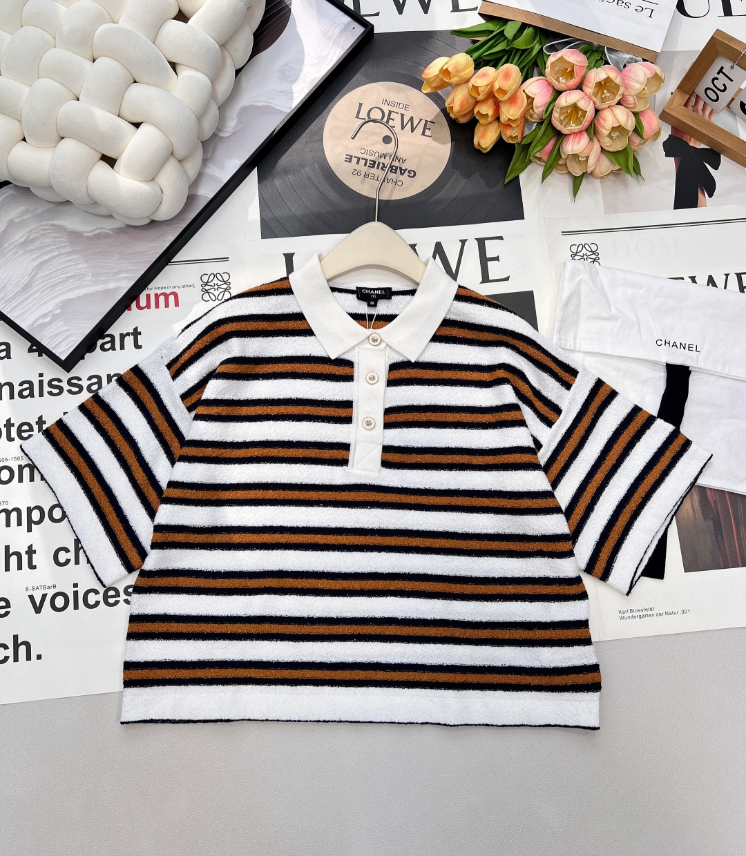 NO:657566,Chanel2025 new knitted striped short-sleeves, customized YB cotton yarn weaving, dense fine knitting, soft and waxy texture, comfortable and skin-friendly, half-open lapel knitted short-sleeved cut, loose silhouette and dropped shoulder design, relaxed neutral style, three-color stripes arranged horizontally on the body, round button camellia decoration, fashionable temperament, rich design layering, fashionable and western style. Comes with exquisite lace dust bag packaging, complete with three labels, two colors  Size sml code,,chanel,T-shirt,alexander wang19860909Chanel2025新款针织条纹短袖,定制YB棉毛纱线织造,密度细针织造,软糯质地,舒适亲肤,翻领半开襟针织短袖剪裁,宽松廓形落肩设计,松弛中性风格拉满,大身三色条纹横向排列,圆扣山茶花装点,穿出时髦气质,丰富设计层次感,穿搭时尚洋气.配有精致系带防尘袋包装 三标齐全,两色出 尺码sml 编码,,chanel,T-shirt,alexander wang,Women's clothing
