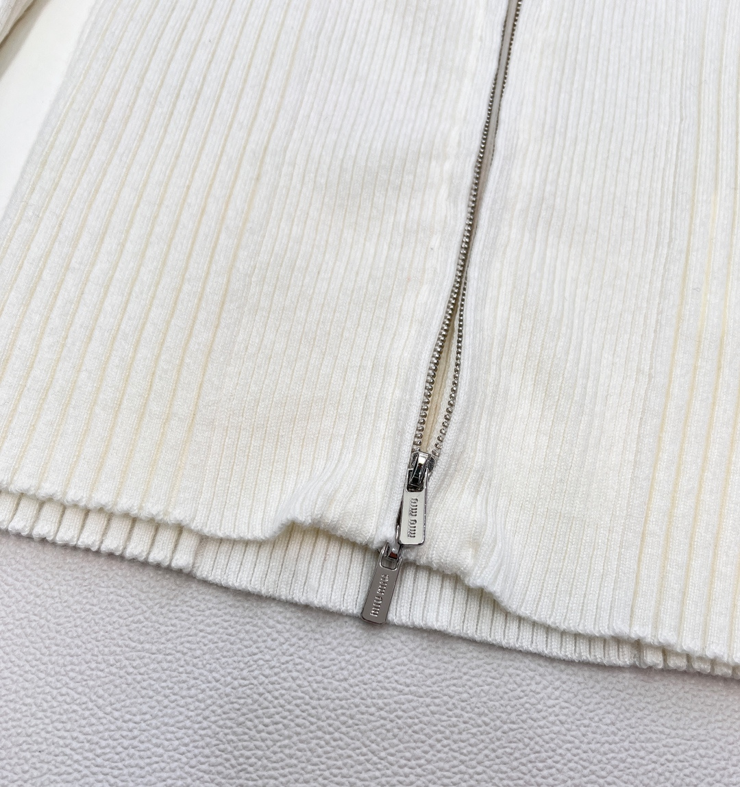 🆕 MIUMIU 新款字母贴片弹力针织开衫这款羊毛针织开衫诠释简约休闲风格。罗纹针织形成别样纹理，短裁版