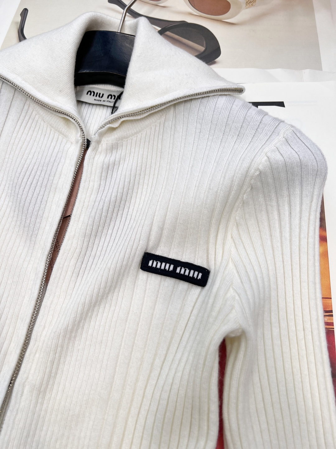 🆕 MIUMIU 新款字母贴片弹力针织开衫这款羊毛针织开衫诠释简约休闲风格。罗纹针织形成别样纹理，短裁版