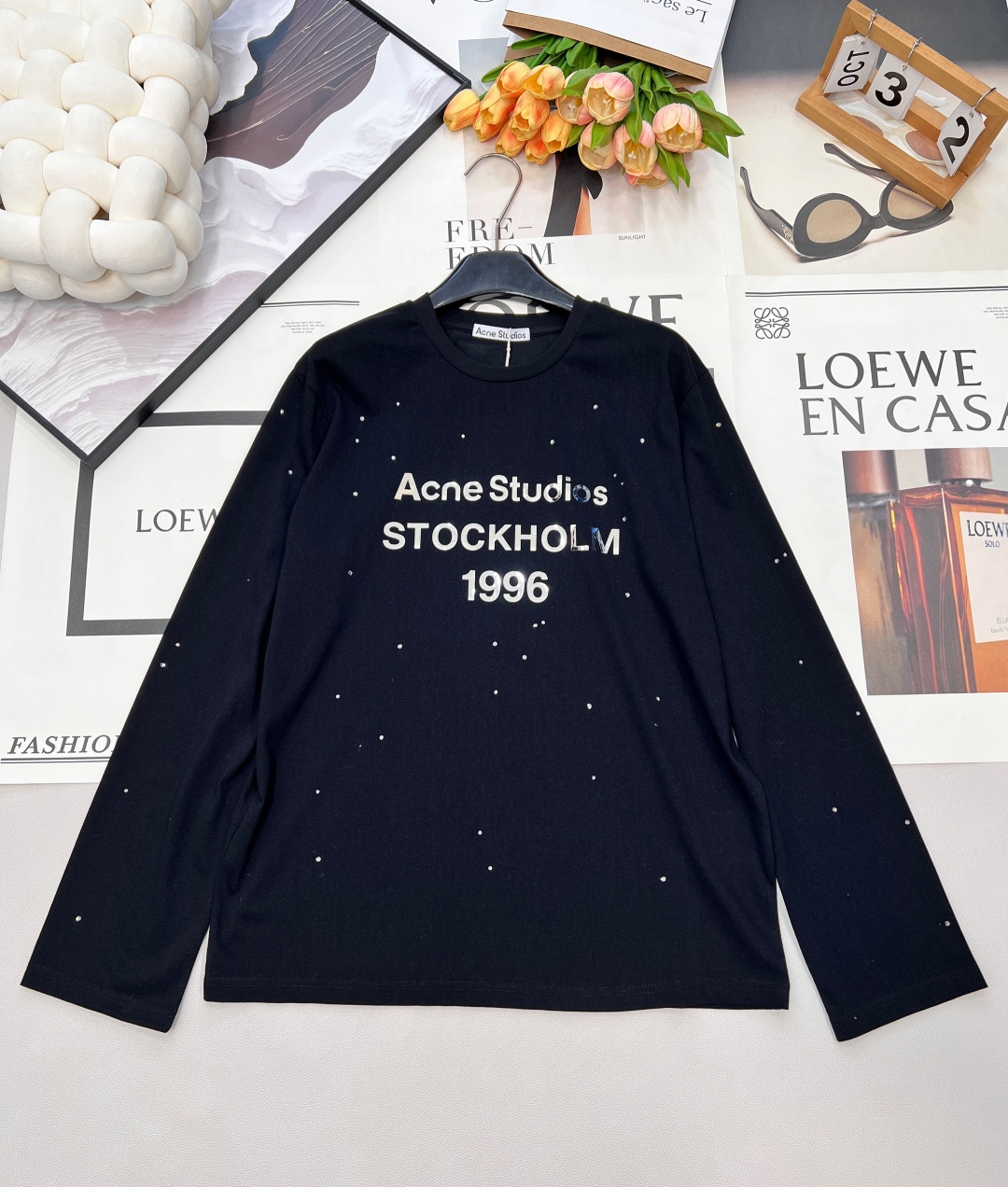 NO:666621,ACNE STUDIO silver label letter print + starry rhinestone long-sleeved T-shirt. The silver letter print is very shiny and textured. It is full of style~ The hot diamonds are scattered in different sizes and have a sense of layering. They are all imported glue and will not fall off easily. The fit is comfortable and loose. The silver label fashion is extremely fashionable. The 1996 series is once again a god!  Heavy studs are printed with letters 'Ac1996' logo, made of cotton and linen blended fabrics. The loose fit is lazy and casual, with a little playfulness. The simple design and luxurious details are perfectly combined to create a unique fashion item. The classic T-shirt style is paired with exquisite studs printing, which reveals a sense of high-end in a low-key manner, showing the brand's unique Nordic minimalist aesthetics. Whether it is daily wear or special occasions, it can easily become the focus. Fashionable, white and rich.  The upper body is full of elegance, can be worn a hundred times without getting tired, and has a unique beauty. It is a piece that looks good no matter how you wear it!  Complete three standards, two colors, size sml code,acne studios,dior,tees,t-shirt, 19860909ACNE STUDIO 银标字母印花+满天星水钻长袖T恤 银色字母印花是很有光泽很有质感的 满满的风格～ 烫钻大小错落有层次感 都是进口胶粘贴不易掉 舒适宽松版型 银标时尚度绝了 1996系列再次封神！ 重工钉钻配上字母印花 “Ac1996”徽标,选用棉麻混纺面料裁制而成 宽松版型慵懒随性 随性中带点小俏皮 将简约设计与奢华细节完美结合,打造出独一无二的时尚单品.经典的T恤版型搭配精致的钉钻印花,低调中透露着高级感,展现出品牌独有的北欧极简美学.无论是日常穿搭还是特别场合,都能轻松成为焦点.  时髦白富美 上身气质满满 百穿不腻 特调的美丽 属于怎么穿怎么好看的一件！三标齐全,两色出 尺码sml 编码,,acne studios,dior,tees，t-shirt, ,Women's clothing
