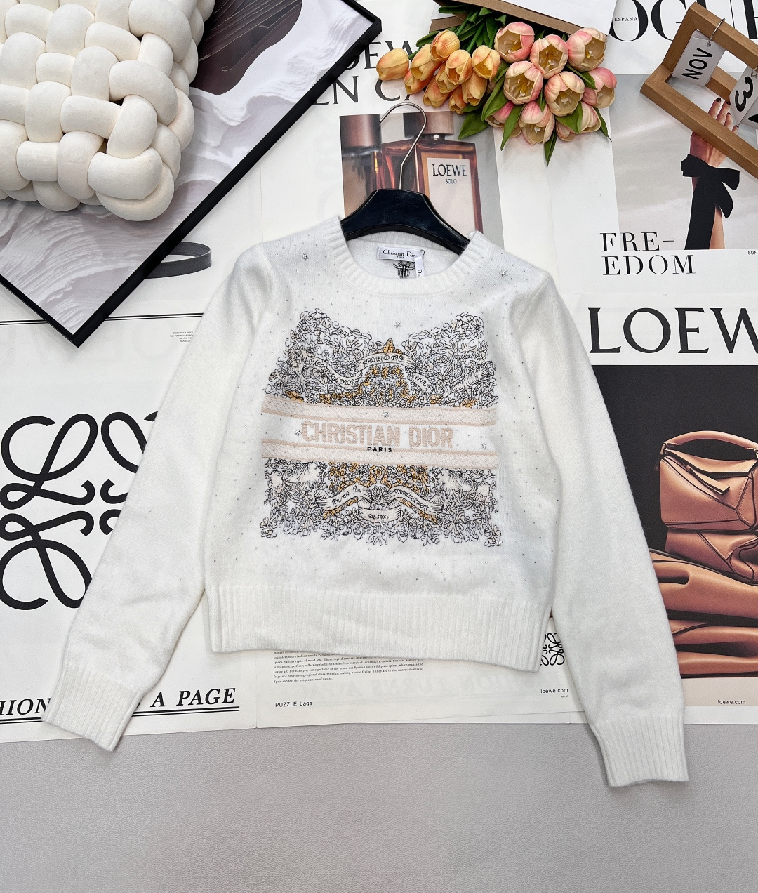NO:685022,DIOR's new letter-embroidered hot-drilled sweater has a classic round-neck cut that outlines neat shoulder and neck lines. The soft and waxy knitted fabric has a delicate touch. It is both warm and textured for winter wear. The body is embellished with exquisite hot-dried diamonds, and the star-like shimmering effect lights up the overall look. The heavy embroidery pattern in the middle area is rich in layers, paired with 'CHRISTIAN  DIOR' letter logo perfectly combines the brand's classic aesthetics with trendy design. Red and white colors are available. The red model is warm and rich, suitable for the festival atmosphere, while the white model is simple and versatile, showing elegance. Whether worn alone or as an inner layer, it is the finishing touch to enhance the sophistication of the look. Complete with three standards, two colors are available. Size sml code D,, dior,19860909DIOR新款字母刺绣烫钻针织衫,经典圆领剪裁勾勒利落肩颈线条,软糯针织面料糅合细腻触感,冬日穿搭兼具温暖与质感.衣身缀满精致烫钻,星光般的细闪效果点亮整体造型；中间区域的重工刺绣纹样层次丰富,搭配「CHRISTIAN DIOR」字母标识,将品牌经典美学与潮流设计完美融合.红白双色可选,红色款热烈浓郁适配节日氛围,白色款简约百搭尽显优雅,无论是单穿还是内搭,都是提升造型精致度的点睛之选.三标齐全,两色出 尺码sml 编码D,,dior,,Women's clothing