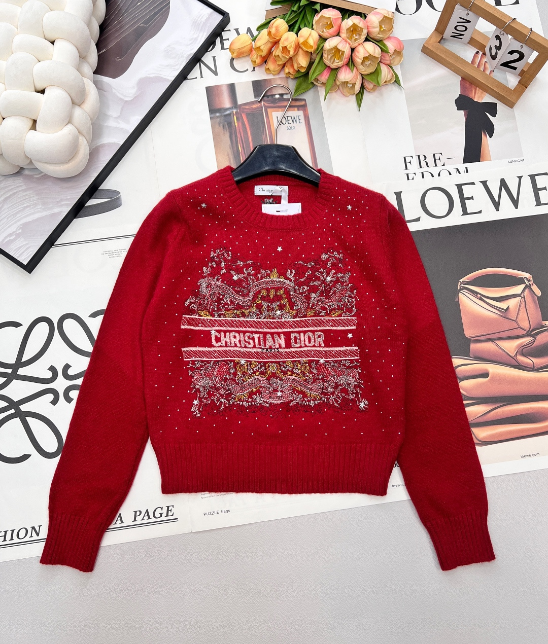 NO:685067,DIOR's new letter-embroidered hot-drilled sweater has a classic round-neck cut that outlines neat shoulder and neck lines. The soft and waxy knitted fabric has a delicate touch. It is both warm and textured for winter wear. The body is embellished with exquisite hot-dried diamonds, and the star-like shimmering effect lights up the overall look. The heavy embroidery pattern in the middle area is rich in layers, paired with 'CHRISTIAN  DIOR' letter logo perfectly integrates the brand's classic aesthetics and trendy design. Red and white colors are available. The red model is warm and rich, suitable for the festival atmosphere, while the white model is simple and versatile, showing elegance. Whether worn alone or as an inner layer, it is the finishing touch to enhance the sophistication of the look. Complete with three standards, two colors are available. Size sml code,, dior,19860909DIOR新款字母刺绣烫钻针织衫,经典圆领剪裁勾勒利落肩颈线条,软糯针织面料糅合细腻触感,冬日穿搭兼具温暖与质感.衣身缀满精致烫钻,星光般的细闪效果点亮整体造型；中间区域的重工刺绣纹样层次丰富,搭配「CHRISTIAN DIOR」字母标识,将品牌经典美学与潮流设计完美融合.红白双色可选,红色款热烈浓郁适配节日氛围,白色款简约百搭尽显优雅,无论是单穿还是内搭,都是提升造型精致度的点睛之选.三标齐全,两色出 尺码sml 编码,,dior,,Women's clothing