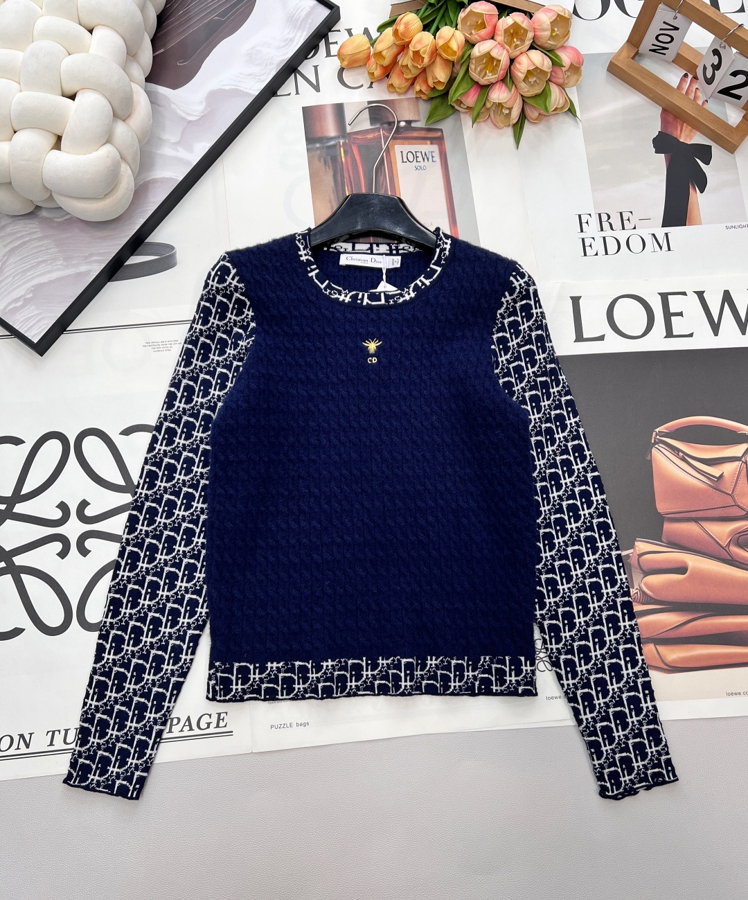 NO:686933,DIOR's new little bee embroidery splicing sweater, customized 70% wool 30% cashmere yarn, navy diamond knitting meets classic CD presbyopia, outlining the fusion aesthetic of retro and exquisiteness. The three-dimensional cable texture of the body shows a soft and waxy texture, and the iconic little bee embroidery falls on the chest.  Gold details become the visual finishing touch; presbyopia elements are stitched into the sleeves and hem, subtly integrating the brand logo into the design. The round neck is loosely tailored to suit a variety of outfits, and the skin-friendly knitted fabric combines comfort and style. It is the best choice for creating a light, luxurious and casual look in autumn and winter. All three standards are complete!  Bulk shipment, size sml code D, dior,19860909DIOR新款小蜜蜂刺绣拼接针织衫,定制的70羊毛30羊绒纱线,藏青菱格针织邂逅经典CD老花,勾勒出复古与精致的融合美学.衣身立体绞花纹理尽显软糯质感,标志性小蜜蜂刺绣落于胸口,金色细节成为视觉点睛之笔；老花元素拼接袖身与衣摆,将品牌标识感巧妙融入设计.圆领宽松剪裁适配多元穿搭,亲肤针织面料兼顾舒适与造型感,是秋冬打造轻奢随性造型的不二之选.三标齐全！大货出 尺码sml 编码D,,dior,,Women's clothing