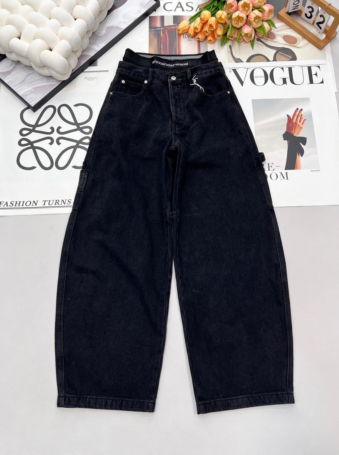 NO:687224,Alexander Wang  25FW new autumn and winter fake two-piece webbing waistband work jeans丨Made of washed distressed denim fabric, stiff and wear-resistant while retaining a natural drape; high waist + wide leg workwear version, the silhouette that naturally unfolds from the crotch can not only modify the leg shape, but also create an 'oversi'  'ze street style' relaxed atmosphere. The waistband is designed with fake two-piece webbing, imprinted with the brand logo, which has both recognition and layering. The three-dimensional workwear pockets on the side + metal snap buttons strengthen the workwear attributes, and the back pockets are matched with leather logos to enhance the texture. Three labels are complete, and two colors are outstanding.  size sml code,,versace,jeans,19860909Alexander Wang 25FW秋冬新款假两件织带腰头工装牛仔裤丨采用水洗做旧牛仔面料,挺括耐磨同时保留自然垂坠感；高腰+阔腿工装版型,从胯部自然展开的轮廓既能修饰腿型,又能营造“oversize街头风”的松弛氛围.腰头采用假两件织带设计,印刻品牌标识,兼具辨识度与层次感；侧边立体工装口袋+金属按扣装饰,强化工装属性,后袋搭配皮质标饰提升质感.三标齐全,两色出 尺码sml 编码,,versace,jeans,,Women's clothing