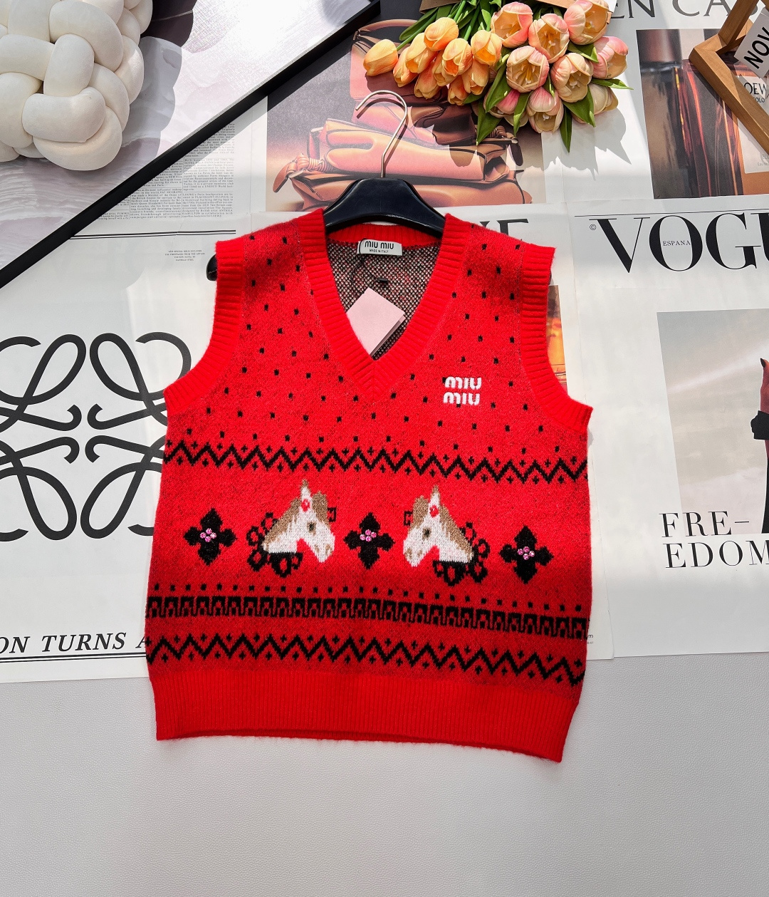 NO:695079,MIU MIU 2026 new V-neck sleeveless knitted vest perfectly combines retro romance and New Year's ritual feeling!  The snowflake dots are scattered and intertwined, creating a hazy texture beauty for the body of the garment; the three-dimensional pony jacquard is fresh and flexible, and paired with the retro pattern of rhombus zigzag patterns, perfectly blending the fairy tale atmosphere with modern accents.  The navy blue model is calm and elegant, with a cool and noble air. It can be worn with shirts and bottoming shirts every day to give a lazy and high-end feel; the red model is warm and bright, which is the finishing touch of New Year's wear. The upper body will instantly fill the festive atmosphere, whether it is visiting relatives.  It is an eye-catching tool for frie19860909MIU MIU 2026新款V领无袖针织背心,把复古浪漫与新年仪式感狠狠拿捏！雪花点纹错落交织,为衣身晕开朦胧的肌理美感；立体小马提花鲜活灵动,搭配菱格锯齿纹的复古纹样,将童话氛围与摩登腔调完美融合. 藏青款沉稳雅致,自带清冷贵气,日常搭衬衫、打底衫都能穿出慵懒高级感；正红款热烈明艳,是新年穿搭的点睛之笔,上身瞬间拉满节日氛围,不管是走亲访友还是聚会出片,都是吸睛利器.软糯针织面料亲肤舒适,V领剪裁修饰脖颈线条,轻松打造甜酷兼具的冬日造型,新年穿它,氛围感直接拉满三标齐全,大货出 尺码sml 编码,,miumiu,shirts,,Women's clothing