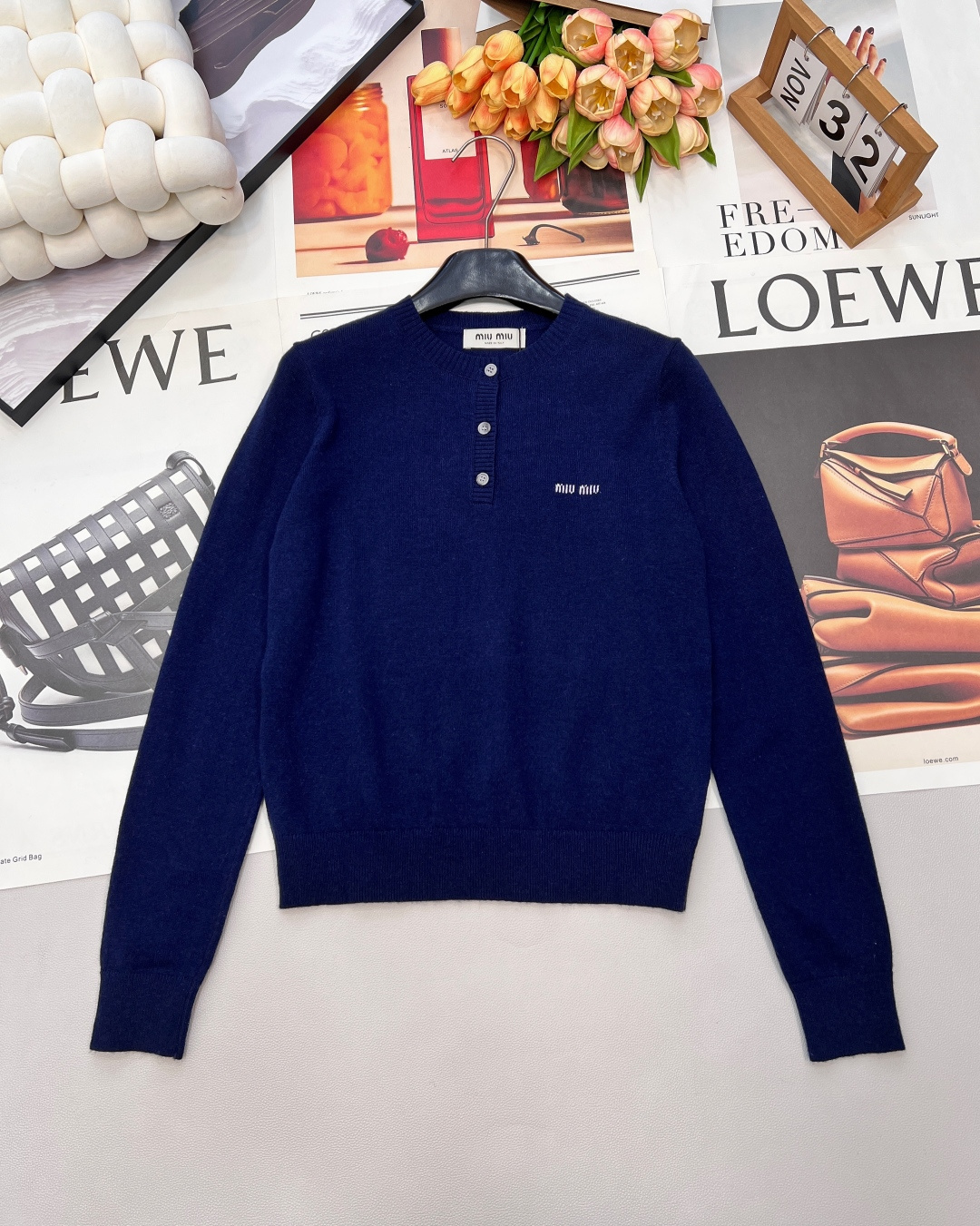 NO:708747,MIUMIU jacquard letter three-button round neck wool sweater Classic two-color replica college style High-end gray｜Retro navy Three-button round neck design Outline the elegant neck line, fine wool knitting Gives a double soft touch, the iconic jacquard letters low-key interpretation of the brand aesthetics Wear alone to show layering The inner layer is more stylish Weaving retro college feelings into the stitches, this three-button round neck wool sweater directly touches the hearts of girls.  The calm and elegance of high-end gray and the rich texture of retro navy blue are available in two colors to suit different moods. The three exquisite buttons on the neckline are the finishing touch, which not only outlines the beautiful neck line, but also allows you to adjust the opening and closing at will, unlocking a variety of styles.  The delicate wool fabric is soft and skin-friendly without being tied, and the double soft touch wraps up the warmth of winter; the iconic jacquard letters on the chest are low-key and integrated into the texture, unobtrusive but full of brand recognition. Paired with a pleated skirt, it is a strong school girl, and with straight pants, it is a casual and cool girl, and it is easy to achieve the sweetness and sass of the college style. Reshaping the classic college style | Lazy and refined coexist, whether it is paired with the gentleness of a skirt or the casualness of jeans  All of them can instantly enhance the texture and recognition of the overall shape. It has three complete standards and two colors. Size, SML code, miumiu, skirts, jeans,19860909MIUMIU 提花字母三粒扣圆领羊毛针织衫 经典双色 复刻学院风 高级灰｜复古藏蓝 三粒扣圆领设计 勾勒优雅颈部线条,细腻羊毛针织 赋予双倍柔软触感,标志性提花字母 低调诠释品牌美学 单穿显层次 内搭更有型 把复古学院情怀织进针脚,这款三粒扣圆领羊毛针织衫,直接戳中少女心. 高级灰的沉静雅致、复古藏蓝的浓郁质感,双色任选适配不同穿搭心境. 领口三颗精致纽扣是点睛之笔,既勾勒出优美颈部线条,又能随心调节开合度,解锁多样造型感. 细腻羊毛面料软乎乎亲肤不扎身,双倍柔软触感包裹冬日暖意；胸前标志性字母提花低调融入肌理,不张扬却满是品牌辨识度.搭百褶裙是元气学姐,配直筒裤是随性酷妹,轻松拿捏学院风的甜与飒. 经典学院风重塑 ｜ 慵懒与精致并存 无论是搭配半裙的温柔,还是牛仔裤的随性 皆能瞬间提升整体造型的质感与辨识度,三标齐全,两色出 尺码sml 编码,,miumiu,skirts,jeans,,Women's clothing