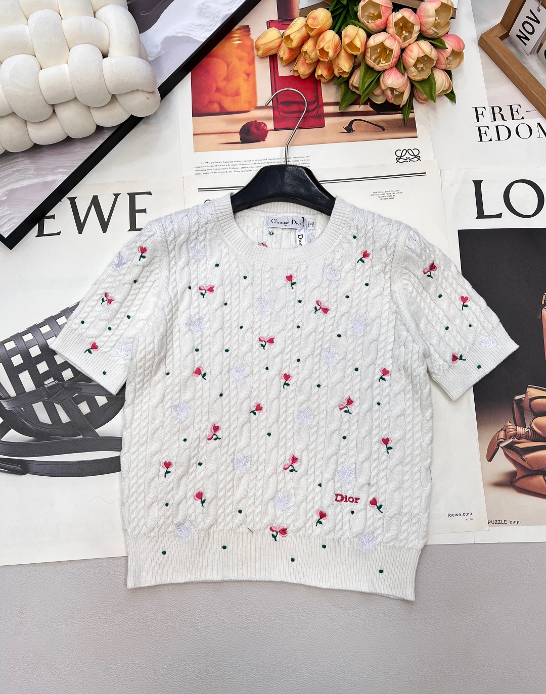 NO:708764,Dior's new short-sleeved knitted sweater from the Little Red Flower series is the perfect addition to your spring wardrobe. The body is made of classic twisted rope weaving to create a three-dimensional and textured visual effect; the scattered little red flowers and white dove embroidery are exquisite and smart, injecting romantic spring into the pure white knitted fabric.  Japanese flavor. The round neck design is simple and elegant, and the short cut is matched with small short sleeves. It is neat and playful, and easily outlines the superior proportions. Whether worn alone to create a French sweet and cool style, or layered with rich layers, it can perfectly unlock spring fashion. Complete three standards, large quantities are shipped  Size sml code D,,dior,T-shirt,19860909Dior新款小红花系列短袖针织衫,是春日衣橱的点睛之选.衣身采用经典麻花扭绳织法,打造出立体又富有肌理感的视觉效果；散落的小红花与白鸽刺绣精致灵动,为纯白针织注入浪漫春日气息.圆领设计简约大气,短款剪裁搭配小巧短袖,利落又俏皮,轻松勾勒出优越比例,无论是单穿打造法式甜酷风,还是内搭叠穿丰富层次,都能完美解锁春日时尚穿搭.三标齐全,大货出 尺码sml 编码D,,dior,T-shirt,,Women's clothing