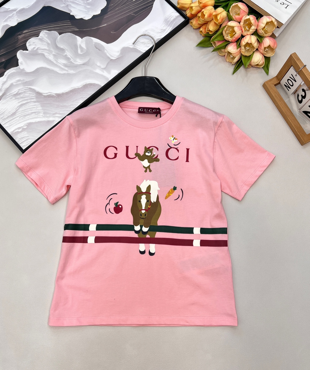 NO:709447,Gucci2026 new Lunar New Year round neck printed pony short-sleeved T-shirt, New Year Lunar New Year series #Customized YB native cotton material, breathable and comfortable, full of texture, slim fit small version of the shirt, using printing technology to outline a cartoon-style cross  The bar pony letter logo is decorated with elements such as carrots and puppies. The colorful collision style is playful and enhances brand recognition. It has clear layers and is suitable for the happy atmosphere of the end of the year. The pink color is eye-catching and youthful, and is a versatile and fashionable daily item. Complete with three labels, large quantities are shipped.  Size sml code G,,gucci,T-shirt,tees,t-shirt,19860909Gucci2026新款贺岁圆领印花小马短袖T恤,新年贺岁系列#定制YB原生全棉材质,透气舒适,质感十足,修身小版恤剪裁,利用印花工艺处理,勾勒出卡通风格的跨栏小马字母徽标装饰,点缀胡萝卜小狗等元素,彩色碰撞画风俏皮,加强品牌辨识度,层次分明,适配年末欢乐氛围的粉红色,亮眼青春,百搭时髦的日常单品.三标齐全,大货出 尺码sml 编码G,,gucci,T-shirt,tees，t-shirt,,Women's clothing