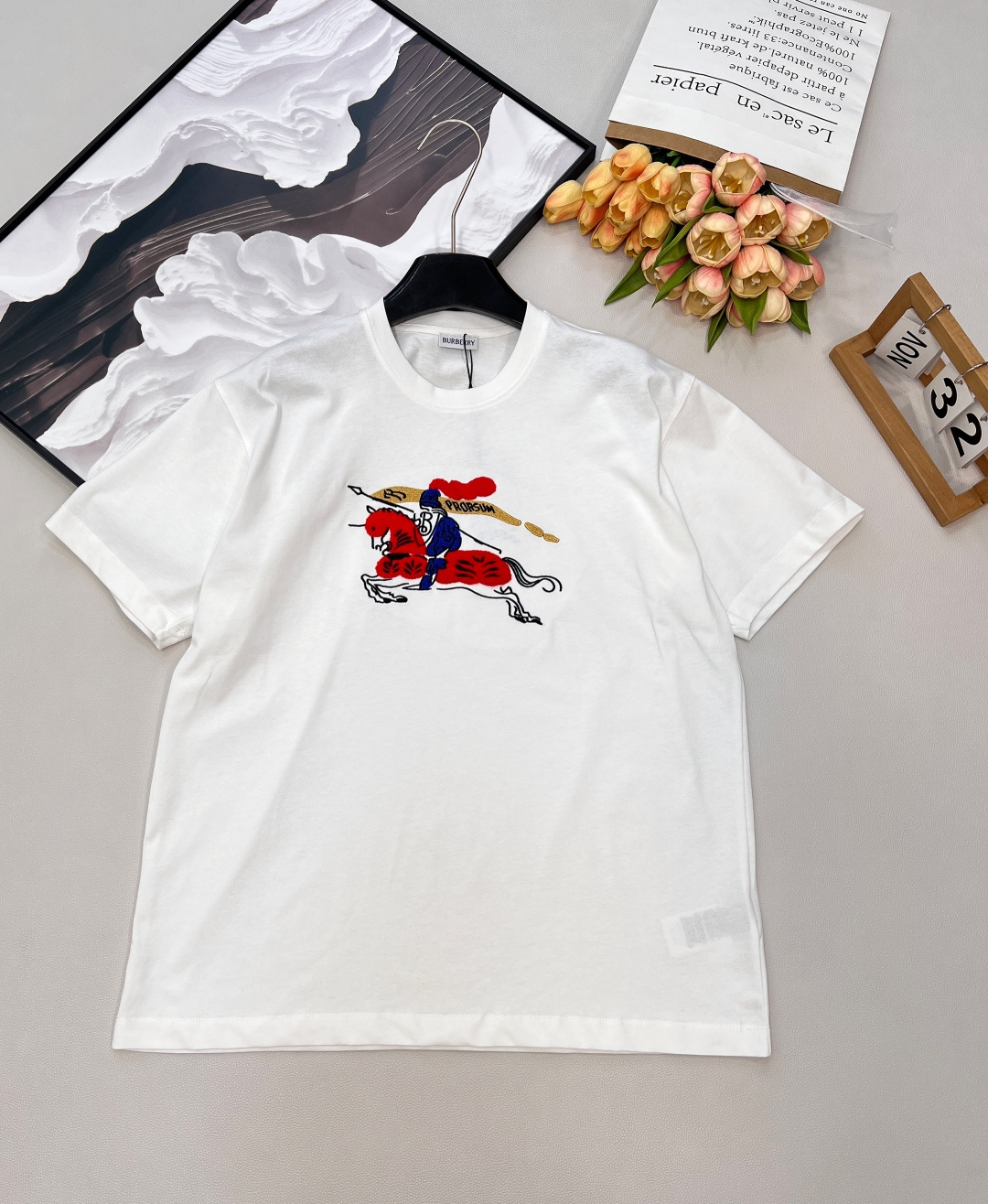 NO:709426,Burbery26SS New Year Limited Equestrian Knight Logo Round Neck Short Sleeve T-Shirt丨Exclusively developed by yb!  High quality production!  The classic round neck cut is matched with a loose silhouette, and soft cotton fabrics are selected to create a comfortable wearing feeling. The embroidered equestrian knight logo on the chest is integrated into the New Year red/pure white two-color design.19860909Burbery26SS新年限定马术骑士徽标圆领短袖T恤丨独家yb开发！高版出品！以经典圆领剪裁搭配宽松廓形,甄选柔软棉质面料打造舒适穿着感.胸前刺绣马术骑士徽标融入新年红/纯净白双色设计,徽标细节采用立体绣艺呈现,新年限定款的红色调更添节日氛围,简约版型适配日常多种穿搭场景,是轻奢休闲与节日仪式感的融合之作.三标齐全,三色出 尺码sml 编码,,burberry,T-shirt,tees，t-shirt,,Women's clothing