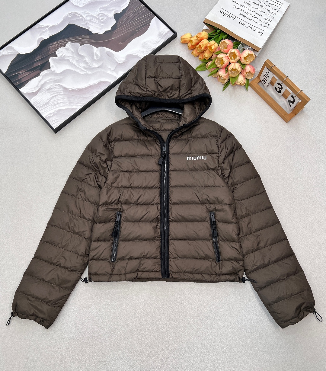NO:713248,Equipped with a dust bag, the MIUMIU logo letter embroidered hooded rib down jacket is made of rich cocoa brown to outline the warm winter silhouette. The brand genes are highlighted in the details. The iconic rib quilting is light and fluffy, locking in warmth. The hooded zipper jacket has a perfect wrap around the upper body!  It's easy to balance warmth and fashion~ The new national standard 90 velvet, the breadstick grid is fully filled!  The fillings inside have gone through a strict selection process, and their fluffiness and resilience are extremely superior, and their cold-proof performance is beyond doubt!  The upper body wrapping sex is the absolute best!  Highly recommended!  It looks so slim, not bloated at all, and very warm!  The hem and sleeves can also be tightened to prevent the wind from getting inside. The classic rib down jacket style, coupled with ultra-exquisite letter embroidery, is both warm and fashionable. Ingeniously blend retro and sweetness to define your winter sense of luxury. In this winter, be your own sweet and cool protagonist. MIUMIU will share the warm time with you. Three standards are complete, large quantities are shipped. Size sml code,, miumiu, jackets & coats, down jacket, hats,19860909配防尘袋MIUMIU 徽标字母刺绣连帽排骨羽绒服,以质感浓郁的可可棕,勾勒冬日温暖轮廓.于细节处彰显品牌基因.标志性排骨绗缝,轻盈蓬松,锁住暖意. 连帽拉链外套上身包裹性绝绝子！保暖与时髦轻松兼顾～ 新国标90绒,面包条格都被填充的满满当当！内里填充物均经过严格的挑选工序,其蓬松感与与回弹性都极为优越,御寒性能更是毋庸置疑！上身包裹性绝绝子！重磅推荐！ 好显瘦,一点也不臃肿,还很保暖！下摆和袖子还可以收紧,不会往里面钻风 经典的排骨羽绒服版型,加上超精致的字母刺绣,保暖和时髦度同时拉满. 将复古与甜美巧妙融合,定义你的冬日高级感. 在这个冬天,做自己的甜酷主角.MIUMIU,与你共绎温暖时光.三标齐全,大货出 尺码sml 编码,,miumiu,jackets & coats,down jacket,hats,,Women's clothing