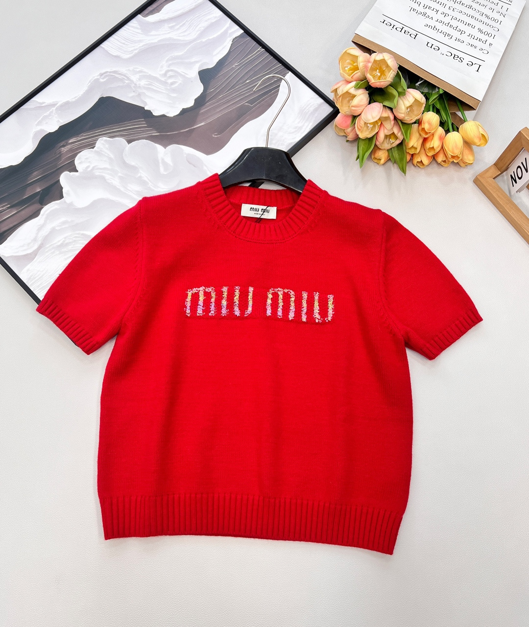 NO:716191,Miu Miu 2026 New Year's limited edition knitted short-sleeve, with a touch of bright New Year's red, is your eye-catching jersey for the beginning of spring!  Highlights of details - The three-dimensional colorful thread logo and the iconic MIUMIU word are embroidered with colorful yarns, with a mottled gradient texture, which is more lively and playful on the red base. - The soft and skin-friendly knitted fabric is made of delicate and untied knitted fabric, which is comfortable and gentle to wear next to the body. The three-dimensional texture makes the simple version look more advanced. - The classic pit design round neck and hem are all done with pit hemming, which is retro and slimming, fits the body shape and optimizes the proportions.  - The short gold cut has just the right length. When paired with high-waisted trousers or pleated skirts, it can easily create a 37-point figure, which is energetic and tall. The New Year red has a festive atmosphere and is eye-catching when worn alone on a daily basis. It can also be the finishing touch when layered with a coat or down jacket. Three standards are complete, and large quantities are shipped. Sizes sml code, miumiu, skirts, T-shirt, down jacket, gold,19860909Miu Miu 2026新年限定针织短袖,一抹明艳的新年红,是属于你的开春吸睛战袍！ 细节亮点 - 立体彩线Logo标志性MIUMIU字样用彩色纱线刺绣而成,自带斑驳渐变质感,在红色基底上更显灵动俏皮. - 软糯亲肤针织选用细腻不扎的针织面料,贴身穿舒适又温柔,立体肌理感让简约版型更显高级. - 经典坑条设计圆领与下摆都做了坑条锁边,复古又显瘦,贴合身形还能优化比例. - 短款黄金剪裁恰到好处的衣长,搭配高腰裤、百褶裙都能轻松打造三七分身材,活力又显高. 新年红自带节日氛围感,日常单穿亮眼吸睛,叠穿大衣或羽绒服也能成为点睛之笔.三标齐全,大货出 尺码sml 编码,,miumiu,skirts,T-shirt,down jacket,gold,,Women's clothing