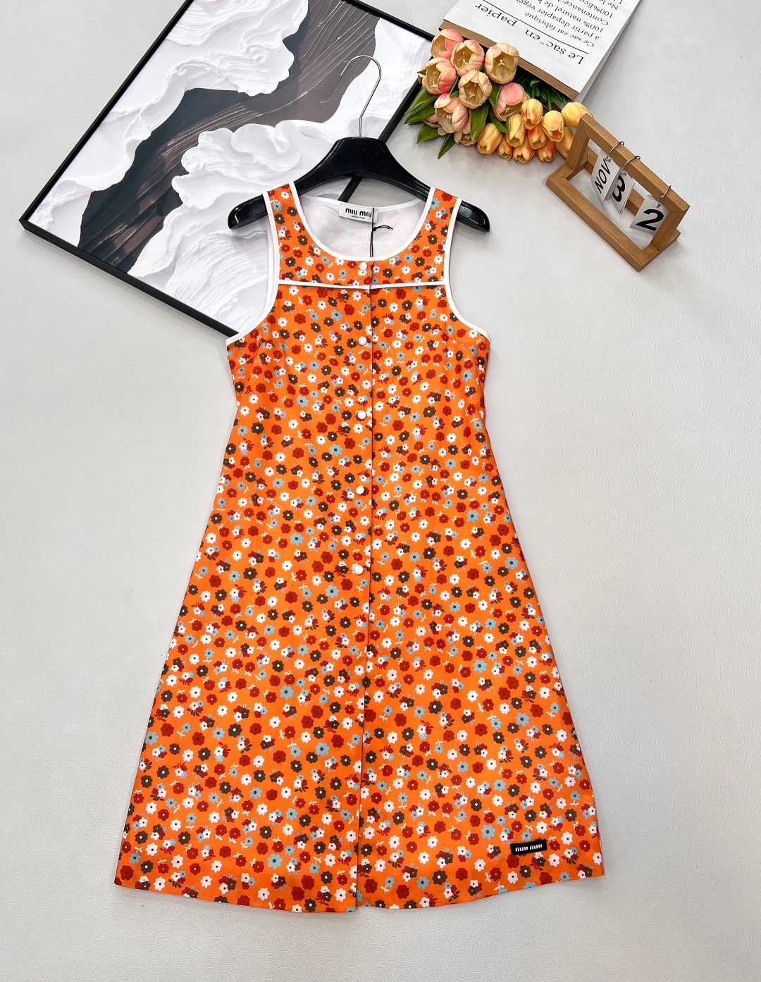 NO:716856,MiuMiu26Ss early spring new retro flower print vest dress丨exclusively developed by yb!  High quality production!  It is based on bright retro orange and is covered with playful floral prints to awaken the vitality of spring. The sleeveless vest has a neat and refreshing silhouette, which outlines the lines of the shoulders and neck. The contrasting edges and front buttons are embellished with details, adding a retro college feel. The light and drapey fabric is suitable for layering in many seasons. Whether worn alone for a picnic or with a suit for commuting, it can become the focus of the style, allowing you to show your girlish elegance and agility in the bright spring weather. Complete with three standards, large quantities are available.  size sml code,,miumiu,skirts,business suit,19860909MiuMiu26Ss早春新款复古花朵印花背心连衣裙丨独家yb开发！高版出品！以明媚复古橙为底,铺满俏皮烂漫的碎花印花,唤醒春日生机.无袖背心版型利落清爽,勾勒肩颈线条；撞色包边与前襟纽扣点缀细节,增添复古学院感.轻盈垂坠的面料适配多季叠穿,无论是单穿奔赴野餐,还是外搭西装通勤,都能成为造型焦点,让你在烂漫春意中,尽显少女式的优雅与灵动.三标齐全,大货出 尺码sml 编码,,miumiu,skirts,business suit,,Women's clothing
