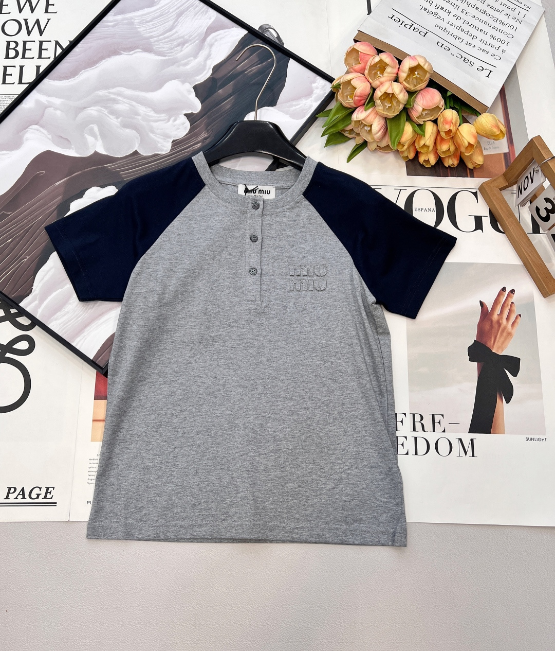 NO:729253,Miu Miu 26Ss early spring new style appliqué embroidered logo casual color block round neck short-sleeved T-shirt丨High version produced!  Based on the retro college style, the classic raglan sleeve design is integrated into daily items. The gray and blue contrasting colors are refreshing and neat, with a relaxed and youthful atmosphere; the three-dimensional appliqué embroidered logo on the chest is a low-key finishing touch, and the delicate texture enhances the overall texture. Soft cotton  The blended fabric has both comfort and stiffness, and the fit is tailored to fit the body shape without being tight. Paired with white wide-leg pants, it is a casual commuting style. Paired with a pleated skirt, it can create a sweet and cool girly look. It is a versatile style that can be worn in the early spring wardrobe. Complete with three standards, large quantities are available.  Size sml code,,miumiu,skirts,T-shirt,tees,t-shirt,19860909Miu Miu 26Ss早春新款贴布绣logo休闲拼色圆领短袖T恤丨高版出品！复古学院风为基调,将经典插肩袖设计融入日常单品.灰蓝撞色清爽利落,自带松弛的青春氛围感；胸前立体贴布绣Logo低调点睛,细腻的纹理感提升了整体质感.柔软的棉混纺面料兼具舒适度与挺括感,合身剪裁贴合身形却不紧绷,搭配白色阔腿裤是随性通勤风,配百褶裙又能演绎甜酷少女感,是早春衣橱里实穿度拉满的百搭款.三标齐全,大货出 尺码sml 编码,,miumiu,skirts,T-shirt,tees，t-shirt,,Women's clothing