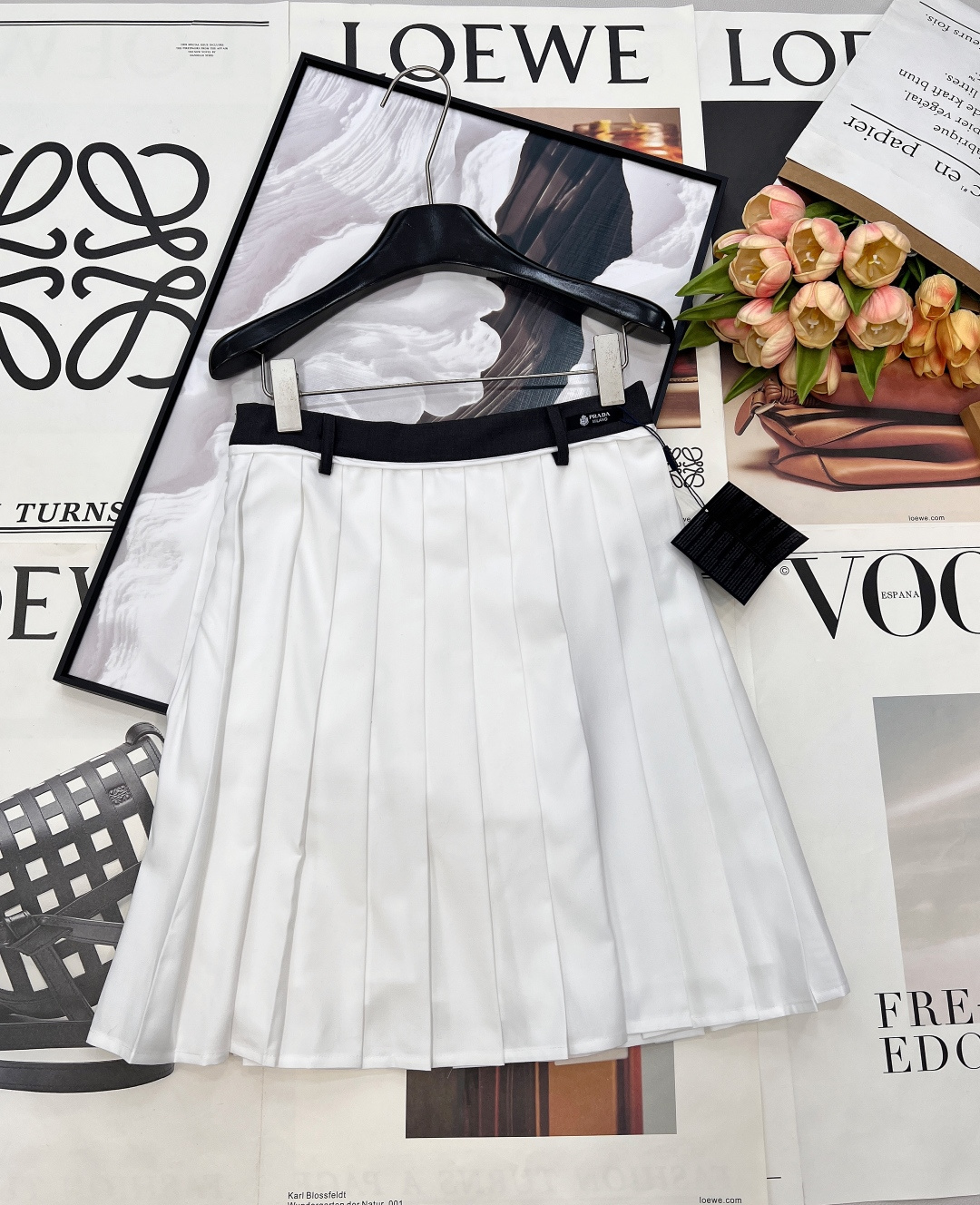 NO:734925,PRADA high-waisted pleated skirt returns to the elegant classics of college style. This PRADA pleated skirt is the finishing touch of the spring and summer wardrobe. The iconic contrasting high-waisted design, paired with the brand logo label, is low-key yet recognizable. The crisp fabric creates three-dimensional and even pleats, which brings a smart rhythm when walking. The neat short cut perfectly modifies the shape of the legs.  Whether paired with a white shirt to create a sweet college look, or combined with a simple T-shirt or sweater, it can be easily adapted. From daily commuting to weekend outings, it is a versatile item that can support the look, allowing you to switch freely between retro and modern. Three standards are complete, and large quantities are shipped. Sizes sml code, prada, skirts, shirts, tees, t-shirt,19860909PRADA 高腰百褶半裙,重回学院风的优雅经典,这条PRADA百褶裙是春夏衣橱的点睛之笔. 标志性的撞色高腰头设计,搭配品牌标识标签,低调中透着辨识度. 挺括面料打造出立体均匀的褶裥,行走间自带灵动韵律. 利落的短款剪裁,恰到好处地修饰腿型. 无论是搭配白衬衫打造清甜学院感,还是与简约T恤、针织衫组合,都能轻松适配. 从日常通勤到周末出街,它都是能撑起造型的百搭单品,让你在复古与现代之间自由切换.三标齐全,大货出 尺码sml 编码,,prada,skirts,shirts,tees，t-shirt,,Women's clothing