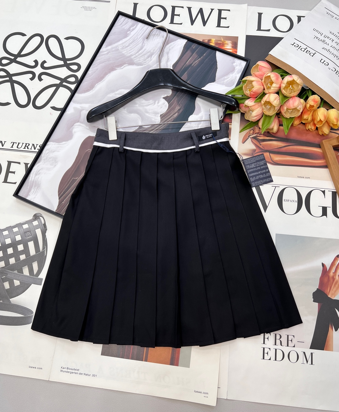 NO:734913,PRADA high-waisted pleated skirt returns to the elegant classics of college style. This PRADA pleated skirt is the finishing touch of the spring and summer wardrobe. The iconic contrasting high-waisted design, paired with the brand logo label, is low-key yet recognizable. The crisp fabric creates three-dimensional and even pleats, which brings a smart rhythm when walking. The neat short cut perfectly modifies the shape of the legs.  Whether paired with a white shirt to create a sweet college look, or combined with a simple T-shirt or sweater, it can be easily adapted. From daily commuting to weekend outings, it is a versatile item that can support the look, allowing you to switch freely between retro and modern. Three standards are complete, and large quantities are shipped. Sizes sml code, prada, skirts, shirts, tees, t-shirt,19860909PRADA 高腰百褶半裙,重回学院风的优雅经典,这条PRADA百褶裙是春夏衣橱的点睛之笔. 标志性的撞色高腰头设计,搭配品牌标识标签,低调中透着辨识度. 挺括面料打造出立体均匀的褶裥,行走间自带灵动韵律. 利落的短款剪裁,恰到好处地修饰腿型. 无论是搭配白衬衫打造清甜学院感,还是与简约T恤、针织衫组合,都能轻松适配. 从日常通勤到周末出街,它都是能撑起造型的百搭单品,让你在复古与现代之间自由切换.三标齐全,大货出 尺码sml 编码,,prada,skirts,shirts,tees，t-shirt,,Women's clothing