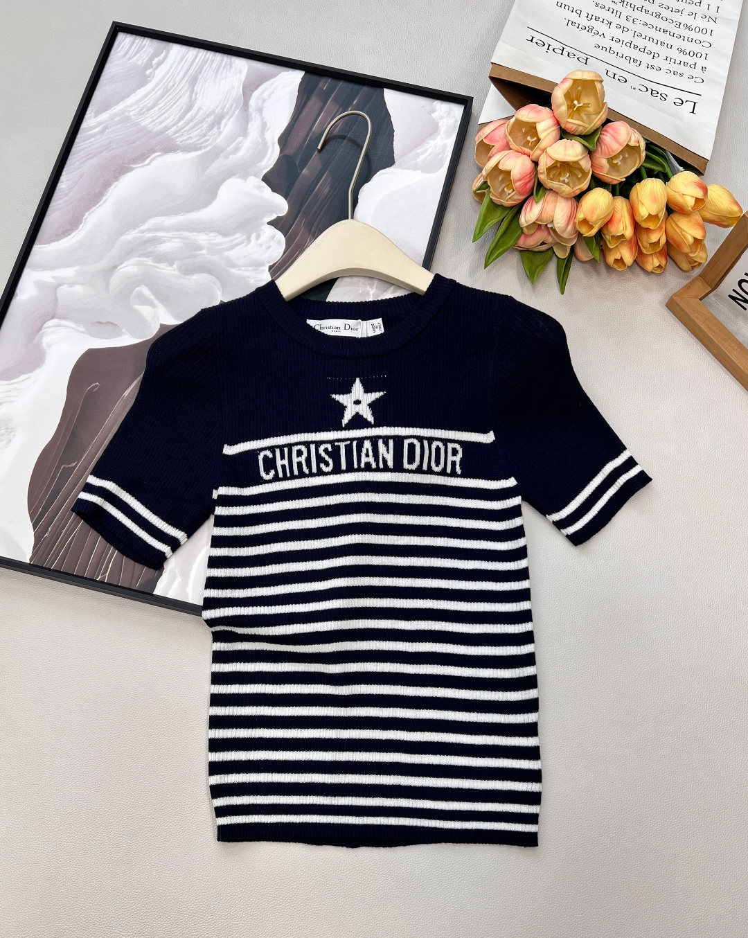 NO:735454,Dior 2026 early spring limited-edition striped knitted short-sleeves, classic stripes collide with American retro elements, blending French elegance and casual vitality into one piece of clothing. It is a must-have versatile item for spring and summer wardrobes - the two colors are bright and eye-catching red stripes, with a festive atmosphere, and the yellow leather upper body becomes white in seconds; the navy stripes are low-key and calm, can be used in daily commuting, and meet different style needs. - Details highlight the star print on the chest echoing 'CHRISTIAN'  'DIOR' letter logo, contrasting stripes on the cuffs, simplicity and ingenuity, making the basic style no longer monotonous. - The skin-friendly pitted knitted fabric is soft and breathable, has micro-elastic properties, and is comfortable and not tight when worn close to the body. The round-neck short-sleeved version is suitable for wearing alone or layered in spring and summer. -  Versatile, pair with jeans to create a casual French style. Pair with a skirt for a sophisticated socialite route. It can be easily used for daily commuting and weekend outings. It is an evergreen style regardless of the occasion. Complete with three standards, large quantities are shipped. Sizes sml code, dior, skirts, jeans, T-shirt,19860909Dior 2026早春限定条纹针织短袖,经典条纹撞上美式复古元素,把法式优雅和随性活力揉进一件衣服里,是春夏衣橱的刚需百搭款 - 双款配色正红条纹明艳吸睛,自带节日氛围感,黄皮上身秒显白；藏青条纹低调沉稳,通勤日常不出错,满足不同风格需求. - 细节亮点胸前星星印花呼应“CHRISTIAN DIOR”字母标识,袖口撞色条纹点缀,简约中透着巧思,让基础款不再单调. - 亲肤质感坑条针织面料柔软透气,自带微弹属性,贴身穿舒适不紧绷,圆领短袖版型适配春夏季单穿或叠穿. - 百搭属性配牛仔裤打造随性法式风,搭半裙走精致名媛路线,日常通勤、周末出街都能轻松驾驭,是不挑场合的常青款.三标齐全,大货出 尺码sml 编码,,dior,skirts,jeans,T-shirt,,Women's clothing