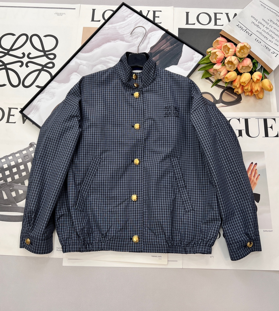 NO:737569,MiuMiu's 2026 spring and summer new college-style pattern jacket unlocks the sense of relaxation in early spring. When the retro plaid meets MiuMiu's girly feel, the blue and gray fine plaid interweaves a gentle college atmosphere. The high-quality cotton fabric is as soft and skin-friendly as clouds. The loose off-shoulder version is casual and hides the flesh, easily creating a lazy and casual atmosphere.  The metal buttons shine brightly on the placket, and the brand embroidery on the chest shows off your identity in a low-key manner. The stand-up collar design can not only resist the slight chill of early spring, but also modify the neck line. Whether worn alone to create a neat look, or layered with sweaters and shirts to create a layered look, it can be perfectly matched with jeans, pleated skirts and overalls, allowing you to easily switch styles in commuting, dating, outings and other scenes. It has become a universal formula for early spring wear. Pair it with skirts from the same series, complete with three standards, and a great deal!  Same style for men and women, size sml code M,,miumiu,skirts,jeans,jackets & coats,shirts,19860909MiuMiu 2026春夏新款学院风格纹夹克,解锁早春松弛感,当复古格纹邂逅MiuMiu式少女感,蓝灰细格纹交织出温柔的学院气息,高品质棉质面料如云朵般柔软亲肤,宽松落肩版型随性又藏肉,轻松打造慵懒随性的穿搭氛围. 金属纽扣在衣襟上熠熠生辉,胸前的品牌刺绣低调彰显身份,立领设计既能抵御早春微凉,又能修饰颈部线条.无论是单穿打造利落造型,还是叠穿针织衫、衬衫营造层次感,它都能完美适配牛仔裤、百褶裙与工装裤,让你在通勤、约会、踏青等场景中,轻松切换风格,成为早春穿搭的万能公式,搭配同系列半裙,三标齐全,大货出！男女同款 尺码sml 编码M,,miumiu,skirts,jeans,jackets & coats,shirts,,Women's clothing