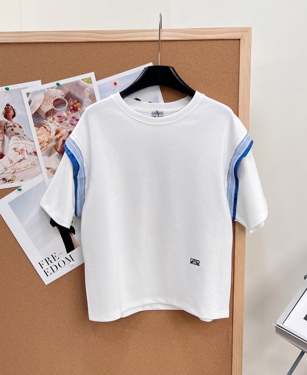 NO:808659,LOEWE 26's new round-neck short-sleeved T-shirt with contrasting sleeve edges is here, a treasure that combines relaxation and design with a sense of relaxation. It is simple and ingenious, making it effortlessly fashionable!   Creamy white/navy blue two-color combination, the low-saturated main color is clean and versatile, paired with the blue and green stripes on the side, it instantly breaks the monotony of the basic style. It is like wearing the summer sea breeze on the body. It is energetic and unobtrusive, and can be easily controlled by yellow-skinned sisters. - The contrasting stripes on the sleeves and side seams are the soul of the entire T-shirt. The stripes of different colors are arranged at random, creating a full sense of layering. It has a sense of flowing lines when walking, and is niche without clashing. -  The low-key LOEWE embroidered logo on the hem is exquisite and compact but highly recognizable. It is unobtrusive but the brand quality can be seen at a glance. It hides light and luxurious details in daily wear - the classic round neck does not flatter the face shape and modifies the neck line. The loose shoulder style is super friendly to sisters with wide and sloping shoulders, making it appear slimmer and hide the flesh.  We select skin-friendly and breathable cotton fabrics, which are soft and skin-friendly without being sweaty. The loose-fitting upper body is lazy and casual, and does not pick up your figure at all. Whether it is paired with denim shorts to create a refreshing casual style, or sports sweatpants for a casual street look, or even layered with a shirt for inner wear, it can be easily held in place. It is a versatile summer style that can be worn in the wardrobe!  All three standards are complete, and the goods will be shipped in large quantities!  Size sml code,,loewe,shorts,shirts,T-shirt,tees,t-shirt,19860909LOEWE 26新款拼接撞色袖边圆领短袖T恤,把松弛感和设计感焊在身上的宝藏款来啦,简约中藏着巧思,轻松拿捏不费力的时髦！  奶白/藏青双色齐发,低饱和的主色调干净又百搭,搭配侧边的蓝绿条纹拼接,瞬间打破基础款的单调感,像把夏日的海风穿在身上,活力又不张扬,黄皮姐妹也能轻松驾驭. - 袖子和侧缝的撞色条纹拼接是整件T恤的灵魂,不同色彩的条纹错落排列,层次感拉满,行走间自带流动的线条感,小众又不撞款. - 下摆低调的LOEWE刺绣logo,精致小巧却极具辨识度,不张扬却一眼能看出品牌质感,把轻奢细节藏在日常穿搭里 - 利经典圆领不挑脸型,修饰脖颈线条,宽松的落肩版型对肩宽、溜肩的姐妹超友好,显瘦又藏肉. 甄选亲肤透气的棉质面料,柔软亲肤不闷汗,宽松的版型上身慵懒随性,完全不挑身材.不管是搭配牛仔短裤打造清爽休闲风,还是配运动卫裤走随性街头感,甚至叠穿在衬衫里做内搭,都能轻松hold住,是衣柜里“一衣多穿”的夏日万能款！三标齐全,大货出！ 尺码sml 编码,,loewe,shorts,shirts,T-shirt,tees，t-shirt,,Women's clothing