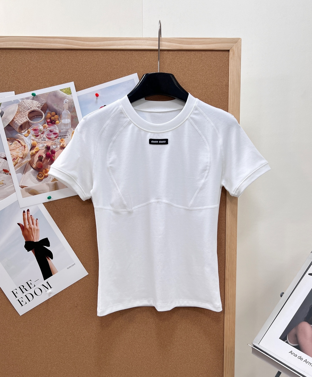NO:837471,MiuMiu's new split-line slim-fitting front-shoulder short-sleeved T-shirt for spring and summer is made of high-elastic soft waxy cotton-feel knitted fabric, which is skin-friendly, delicate, breathable and not sweaty, draping, anti-wrinkle and not easily deformed. It is comfortable and unrestricted to wear close to the body, and there is no pressure in daily sedentary wear in spring and summer. 1. The black label patch with the iconic brand letters on the chest is low-key and refined, and has high-end brand recognition.  2. Three-dimensional arc-shaped segmented line tailoring, accurately modifying the waist and abdomen lines, with built-in waist shaping effect, making you look slim but not tight. 3. Neat shoulder design, optimized shoulder and neck ratio, both slippery and narrow shoulders can be perfectly modified, and the upper body is tall and elegant. 4. Simple round neck + hemmed short sleeves, clean and tidy without being picky about style, versatile but not exaggerated. The classic black, white and gray three colors are versatile and will never go out of style, regardless of skin color or matching.  The short fit version has a high waistline to make the legs look longer, and is friendly to small people. Wear it alone for a cool and pure look, or layer it with a vest or jacket for a layered look. It can be matched with jeans, work skirts, and casual pants. It can be easily used for daily commuting and outings and dates. It is a must-have base layer top for spring and summer. It has three standards and is available in large quantities!  Size sml,,miumiu,skirts,jeans,jackets & coats,T-shirt,tees,t-shirt,19860909MiuMiu春夏新款分割线修身正肩短袖T恤甄选高弹软糯棉感针织面料,亲肤细腻透气不闷汗,垂顺抗皱不易变形,贴身穿着舒适无束缚,春夏日常久坐穿搭零压力. 1.胸前标志性品牌字母黑标贴片,低调精致,高级感品牌辨识度拉满 2.立体弧形分割压线剪裁,精准修饰腰腹线条,自带收腰塑形效果,显瘦不紧绷 3.利落正肩版型,优化肩颈比例,溜肩、窄肩都能完美修饰,上身挺拔显气质 4.简约圆领+包边短袖,干净利落不挑风格,百搭不浮夸 经典黑白灰三色百搭永不过时,不挑肤色不挑搭配 短款合身版型,拉高腰线显腿长,小个子友好 单穿清冷纯欲,叠穿马甲、外套层次感十足 搭配牛仔裤、工装短裙、休闲裤全场景适配,通勤日常、出游约会都轻松驾驭,是春夏万年百搭刚需打底上衣,三标齐全,大货出！ 尺码sml,,miumiu,skirts,jeans,jackets & coats,T-shirt,tees，t-shirt,,Women's clothing