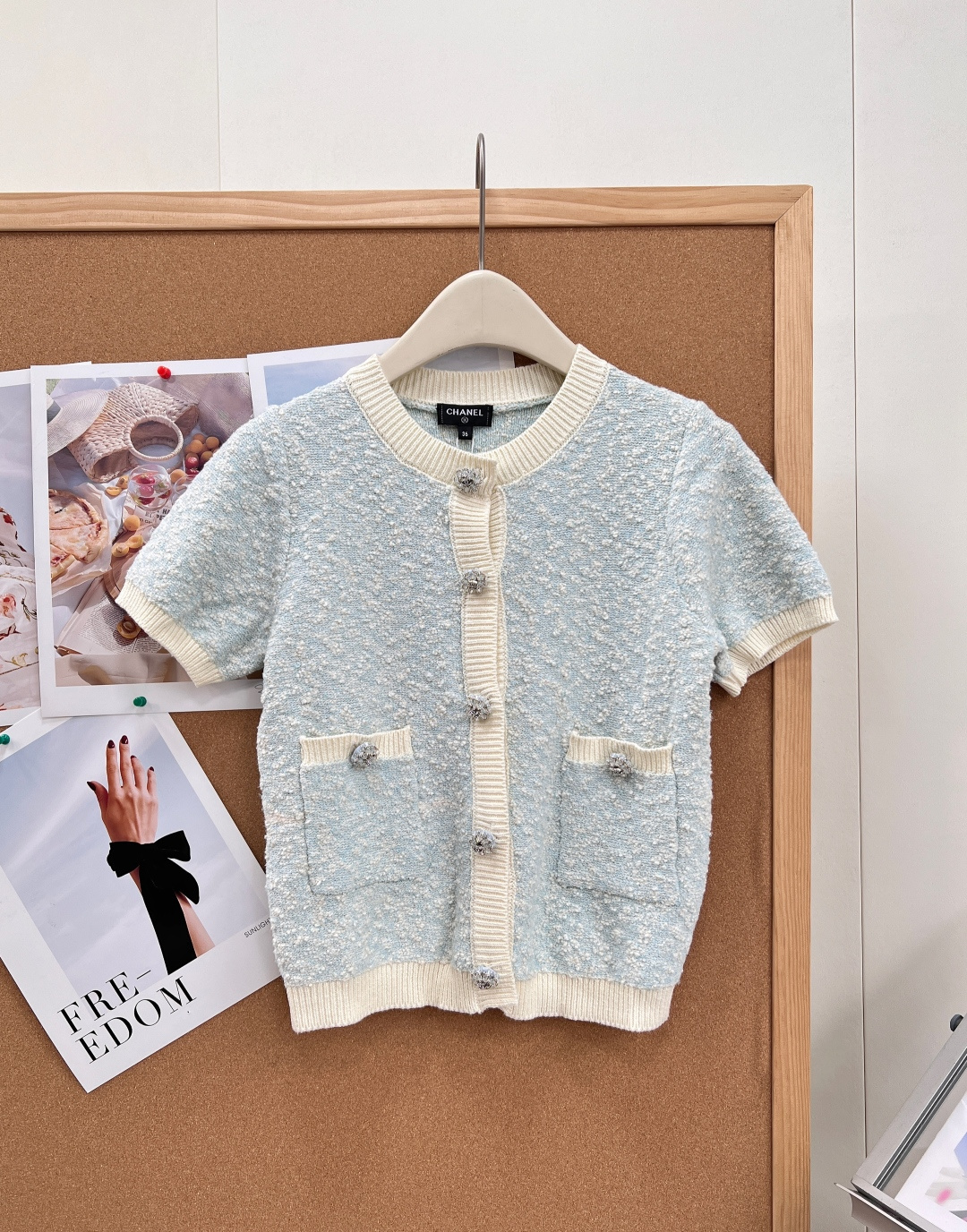 NO:909463,CHANEL's new haze blue contrast diamond button short-sleeved knitted cardigan, 26 spring and summer new variegated grain texture knitting, off-white contrast binding, full set of flower rhinestone buttons, symmetrical double patch pockets, made of custom blended grain loop knitting yarn,  After weaving, it forms a concave and convex three-dimensional fabric texture, which is soft and fluffy to the touch, breathable and sweat-wicking, and does not feel stuffy when worn in spring and summer. It is dyed with a low saturation haze blue color, which is soft and does not pick out yellow/white skin. It is visually refreshing and healing, and it is not easy to pill or fade after washing.  1 Classic small round neck design, fits the neck line, modifies the collarbone, is simple and elegant, and does not highlight the face shape. 2. Fitted short length, naturally raises the waistline, creating a 37-point figure, and is friendly to small people. 3. Short-sleeved cut with right shoulder, modified shoulder line, weakened slip/wide shoulders, and neat sleeve length without pressing the arms. 4. The ribbing at the hem is tightened, which is stable and not easy to loose and deform, and the upper body is flat and slim.  A full set of custom-made three-dimensional flower-shaped diamond buttons, the main placket button + pocket buttons on both sides are unified and matched, multi-faceted rhinestone inlays, strong and not easy to fall off, low-key sparkle enhances the exquisite luxury of the whole dress, replica of the original hardware texture of the counter. Complete with three standards, large quantities of goods!  Size sml code,,chanel,T-shirt,19860909CHANEL新款雾霾蓝撞色钻扣短袖针织开衫,26春夏新款杂色颗粒肌理针织、米白撞色包边、全套花朵水钻纽扣、对称双贴袋,采用定制混纺颗粒圈圈针织纱,织造后形成凹凸立体面料肌理,触感软糯蓬松,透气排汗,春夏穿着无闷肤感；定染低饱和雾霾蓝配色,柔和不挑黄皮/白皮,视觉清爽治愈,水洗不易起球、掉色. 1经典小圆领设计,贴合脖颈线条,修饰锁骨,简约大方不挑脸型 2.合身短款衣长,自然抬高腰线,打造三七分身材,小个子友好 3.正肩短袖剪裁,修饰肩线、弱化溜肩/宽肩,利落袖长不压手臂 4.下摆罗纹收紧,稳固版型不易松垮变形,上身平整显瘦 全套定制立体花朵造型钻扣,门襟主扣+两侧口袋扣统一配套,多面切割水钻镶嵌,牢固不易脱落,低调闪耀提升整件衣服精致奢华感,复刻专柜原版五金质感.三标齐全,大货出！ 尺码sml 编码,,chanel,T-shirt,,Women's clothing