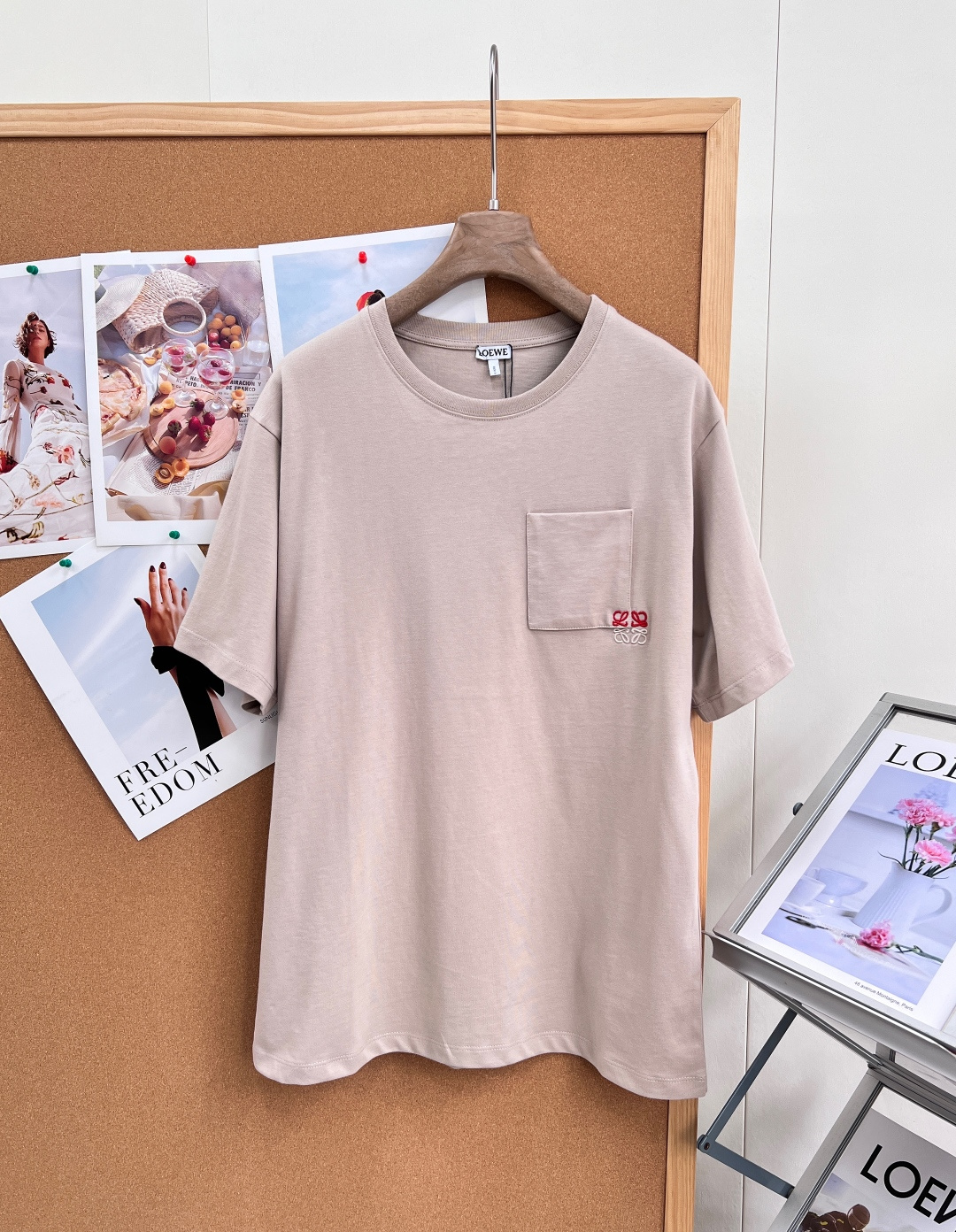 NO:911670,LOEWE's new Anagram embroidered pocket round neck short-sleeved T-shirt is made of 97% combed cotton and 3% spandex high-elastic jersey. The gray fabric has been treated with liquid ammonia mercerization and pre-shrunk washing. The cloth surface presents a delicate matte soft texture, which combines the breathability and skin-friendly properties of cotton with the excellent rebound and anti-deformation properties of spandex.  The shape is a slightly loose straight silhouette with dropped shoulders. The neckline is made of the same fabric as the elastic ribbed round collar. The inner collar is sewn with lock collar technology to long-term resist the stretching and looseness of the neckline after repeated washing. The left chest of the body is sewn with a square patch pocket of the same cut. The pocket mouth is reinforced with double-needle flat lathe stitching. The corners of the pocket are made of contrasting red and white three-dimensional electronics.  The brand's iconic Anagram interwoven totem is sewn using brain embroidery technology. The embroidery base fabric is flat and the stitches are dense and full without floating lines. The shoulder seams and side seams are uniformly reinforced with four-thread overlock seams. The cuffs and hem are seamed with narrow hems and double-needle flat machines. The entire back piece is undivided to simplify the structural lines.  The low-saturated light khaki base is paired with contrasting logo embroidery. It combines high-elastic mercerized knitted fabric, fine three-dimensional embroidery technology and a minimalist casual off-shoulder style. It takes into account the needs of daily single wear and layering. It has three standards and is available in large quantities!  Size sml code,,loewe,T-shirt,tees,t-shirt,19860909LOEWE新款Anagram刺绣口袋圆领短袖T恤 采用97精梳棉搭配3氨纶的高弹平纹针织汗布,坯布经过液氨丝光与预缩水洗工艺处理,布面呈现细腻哑光柔润肌理,兼具棉的透气亲肤与氨纶带来的优良回弹抗形变性能 版型为微宽松落肩直身廓形,领口采用同面料筒织弹力罗纹圆领,领内环缝锁领工艺,长效抵御多次水洗后领口拉伸松垮；衣身左胸缝制同裁片方形贴袋,袋口双针平车压线加固,袋角采用红、白撞色立体电脑绣花工艺缝制品牌标志性Anagram交织图腾,绣花底布平整、针脚密实饱满无浮线；肩缝、侧缝统一采用四线锁边包缝加固,袖口与下摆采用窄幅折边双针平车收缝,后片整片无分割裁片简化结构线条 低饱和浅卡其基底搭配撞色标识刺绣,将高弹丝光针织面料、精细立体绣花工艺与极简休闲落肩版型融合,兼顾日常单穿与层次叠穿需求,三标齐全,大货出！ 尺码sml 编码,,loewe,T-shirt,tees，t-shirt,,Women's clothing
