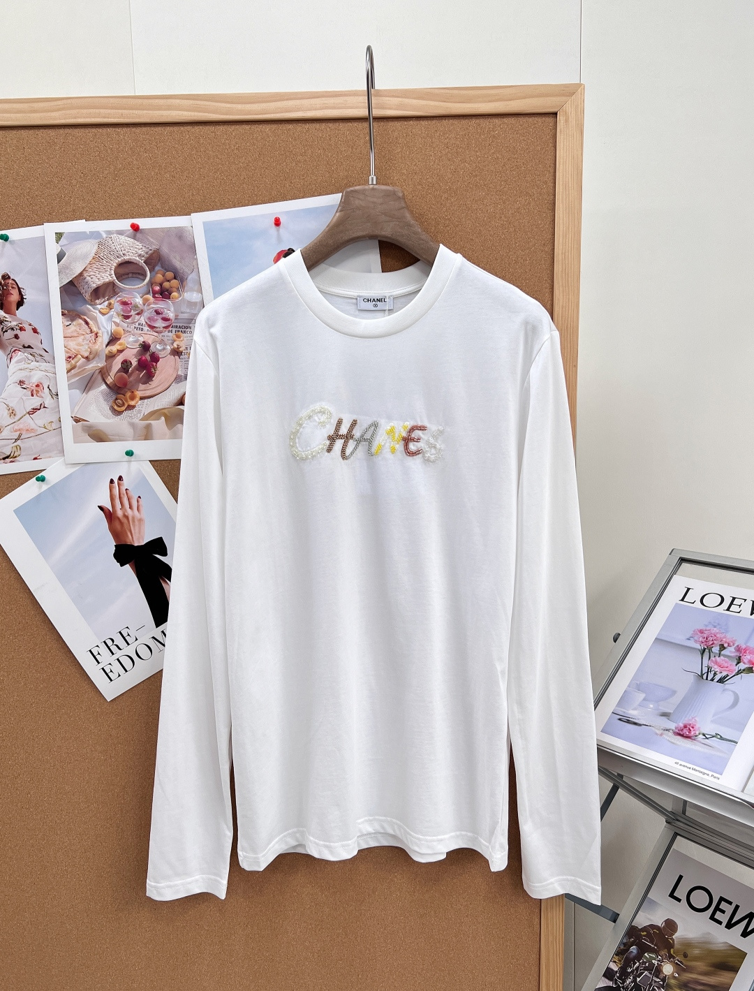 NO:924568,CHANEL Xiaoxiang 2026 spring and summer colorful pearl embroidered long-sleeved T-shirt is made of high-count soft waxy cotton fabric, which is delicate and skin-friendly, breathable and not sweaty, can be worn in all seasons, and will not deform and pill easily after long-term washing. Classic basic round neck design, the collar edge neatly fits the neck; slightly loose and slim long-sleeved version, modifying the arm lines, not tight or bloated, and can be controlled by small / fat figures.  The iconic brand letters on the chest are made with multiple techniques, with gradient color embroidery thread and handmade pearl inlays, which are rich and three-dimensional, exquisite and high-end, and full of recognition. Available in two basic classic colors, black and white, suitable for all bottoms, jeans, skirts, and suit pants. It can be worn alone in spring and summer, as an inner layer in autumn and winter, and suitable for commuting, leisure, and dating in many scenarios. The original pattern is reproduced, and the detailed workmanship is benchmarked against the counter. It is a light luxury item for daily wear. Complete with three standards, large quantities are available!  Size sml code,,chanel,skirts,jeans,tees,t-shirt,business suit,19860909CHANEL小香2026春夏彩色珍珠刺绣长袖T恤,甄选高支软糯棉质面料,触感细腻亲肤,透气不闷汗,四季可穿,久洗不易变形起球. 经典基础圆领设计,领边工整贴合脖颈；微宽松修身长袖版型,修饰手臂线条,不紧绷不臃肿,小个子/微胖身材均可驾驭. 胸前标志性品牌字母采用多重工艺打造,渐变彩色绣线搭配手工珍珠镶嵌,层次丰富立体,精致高级,辨识度拉满. 黑白两款基础经典色,适配所有下装,牛仔裤、半裙、西装裤随意搭配；可春夏单穿,秋冬作为内搭打底,通勤休闲约会多场景适配.原版打版复刻,细节做工对标专柜,日常穿搭刚需轻奢单品.三标齐全,大货出！ 尺码sml 编码,,chanel,skirts,jeans,tees，t-shirt,business suit,,Women's clothing