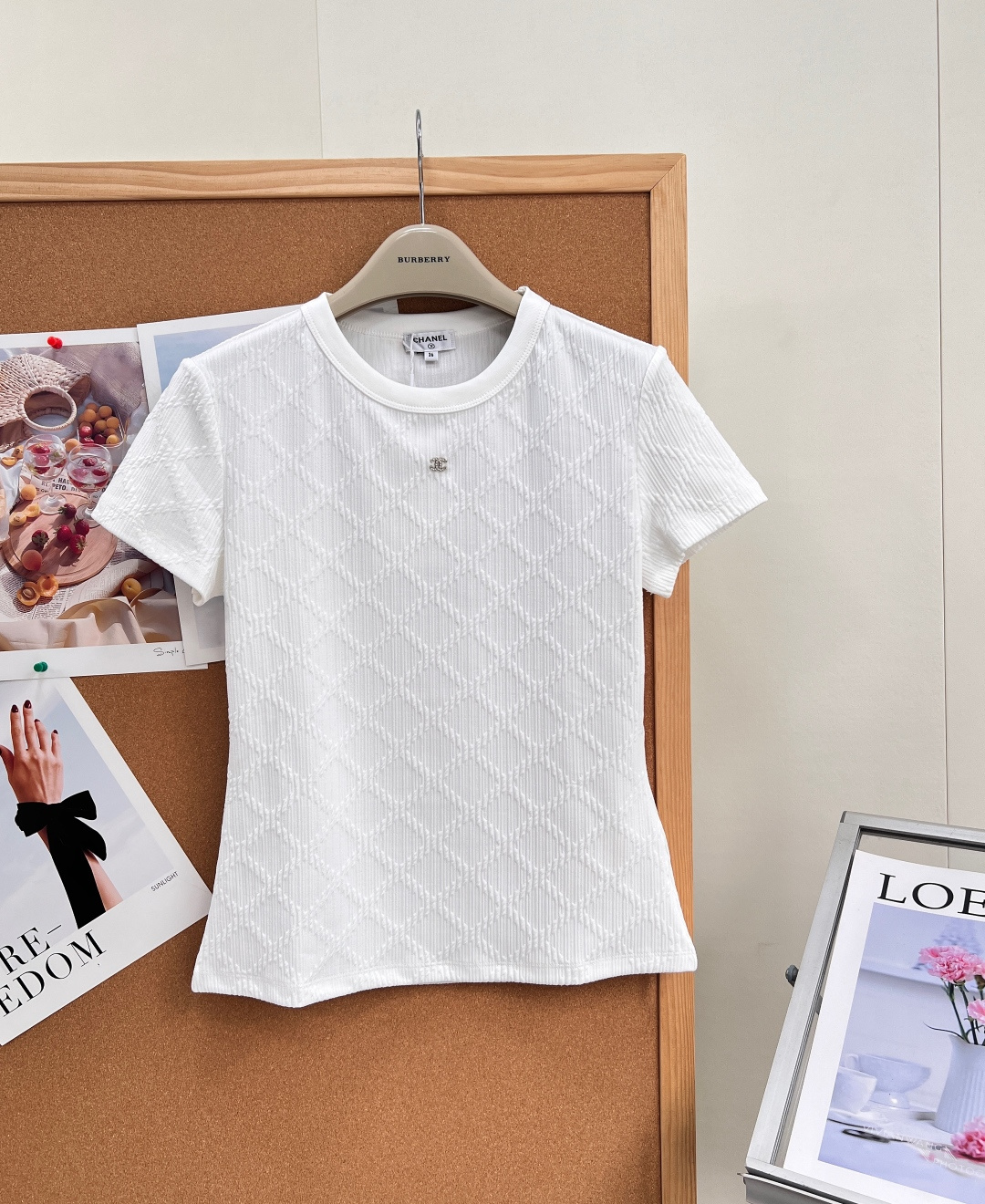 NO:934639,CHAENL's new small fragrant embossed rhombus jacquard round neck short sleeves, three-dimensional rhombus texture jacquard all over, breathable and elastic, low-key and dignified, just need a white T-shirt, the original finely crafted basic ceiling, say goodbye to the monotonous ordinary white T-shirt, the texture is directly full!  The whole piece is made of three-dimensional rhombus embossed jacquard, and the vertical texture is intertwined with rhombus plaids. It feels uneven and delicate. It looks clean and solid from a distance, and it is full of exquisite craftsmanship when seen up close. It is subtle and high-end without being exaggerated. The soft and waxy breathable textured knitted fabric has its own micro-elasticity. It is close-fitting and refreshing without being sweaty. It is suitable for both spring and summer wear as well as autumn and winter inner wear.  Classic and simple small round neck, ribbed cuff is not easy to deform; mini diamond-encrusted double C metal logo on the chest, small and exquisite as the finishing detail, with a light and luxurious atmosphere. Slightly narrowed waist fit tailoring, softly modify the waist and abdomen lines, short sleeves just enough to cover the arm fat, easy to control for small and fat girls.  It is suitable for matching with jeans, suit pants, satin skirts, and small jackets. It is versatile for commuting, dating, and daily shopping. One piece will last for many years and will never go out of style. Complete with three standards, large quantities!  Size sml code,,skirts,jackets & coats,T-shirt,tees,t-shirt,business suit,19860909CHAENL新款小香浮雕菱格提花圆领短袖,全身立体菱形肌理提花,透气弹力,低调显贵刚需白T,原版精工打造的基础款天花板,告别单调普通白T恤,肌理感直接拉满！ 整件满幅立体菱格浮雕提花,竖纹肌理交织菱形格纹,触感凹凸细腻,远看干净纯色,近看满满精致工艺,含蓄高级不浮夸. 软糯透气肌理针织面料,自带微弹力,贴身清爽不闷汗,春夏单穿、秋冬内搭都适配. 经典简约小圆领,罗纹收口不易变形；胸口迷你镶钻双C金属徽标,小巧精致作为点睛细节,轻奢氛围感拿捏. 微收腰合身剪裁,柔和修饰腰腹线条,短袖恰到好处遮住手臂赘肉,小个子、微胖女生都好驾驭. 搭配牛仔、西装裤、缎面半裙、小香外套皆适配,通勤、约会、日常逛街万能百搭,一件穿多年永不过时.三标齐全,大货出！ 尺码sml 编码,,skirts,jackets & coats,T-shirt,tees，t-shirt,business suit,,Women's clothing