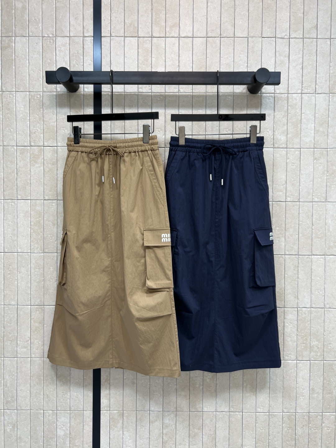 NO:790242,MIU's 26 new spring and summer style elastic waist work style skirt is light and breathable, perfect for summer!  The high-waisted drawstring + A-line shape makes you look slimmer and flatters your body proportions. The back slit design is super convenient for walking ~ multiple pockets are practical and fashionable, and the brand embroidery details on the skirt are perfect. It can be easily controlled for daily commuting, street wear, and outdoor activities. Pair it with a T-shirt or vest to easily get American casual style!  Two colors and three sizes S-M-L,,miumiu,skirts,tees,t-shirt,19860909MIU家 26春夏新款 松紧腰工装风半身裙 轻薄透气超适合夏天！高腰抽绳+A字版型 显瘦又修饰身材比例 后开叉设计走路超方便~多口袋实用又时髦,裙身品牌刺绣细节满分 日常通勤、街头穿搭、户外活动都能轻松驾驭 搭配T恤或背心 轻松get美式休闲风！两色三码 S-M-L,,miumiu,skirts,tees，t-shirt,,Women's clothing