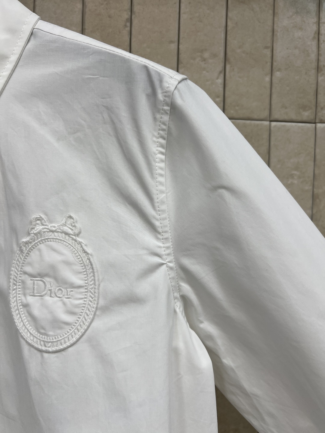 D家 26春夏新款 刺绣徽章衬衫 经典翻领+宽松版型 面料挺括透气 胸前精致同色系徽章刺绣 简约大气 前