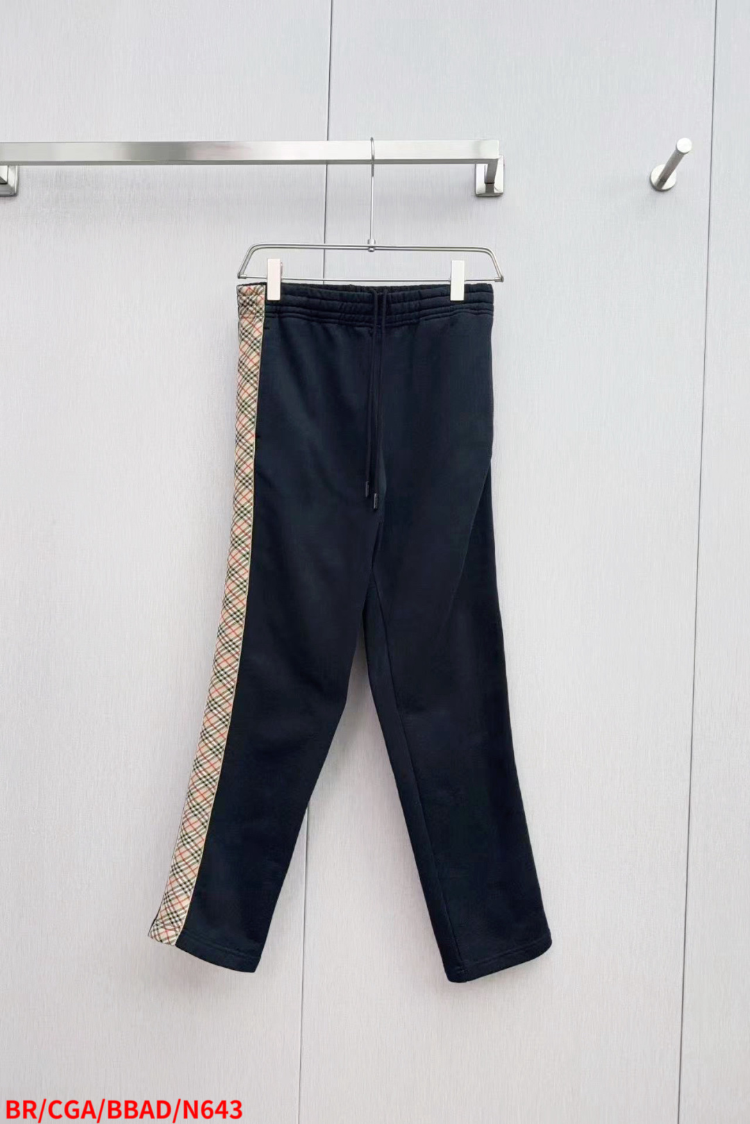 NO:445011,N643 BRBurberry ss new plaid trousers are made of single-sided fish scale fabric woven with cotton as the base. The front is a smooth knitted surface. The touching surface is formed by the floating thread knitting technology of the knitting machine to form a three-dimensional terry loop, which increases the fluffy feeling and is delicate at the same time. The terry loop structure absorbs a large amount of water and evaporates quickly, and it is not easy to deform loosely after multiple washings. The monochrome flat embroidery above the back patch body controls the coordinated operation of the machine head, needle rod and spool through the high-precision calculation system of the computer embroidery machine. The fabric frame moves accurately in the horizontal and vertical directions to form a stitch trajectory, adjust the tension of the upper and lower lines to ensure that the stitch is flat and there is no floating line, forming a fine pattern with an error of ±0.1mm.  The fabric is evenly humidified by steam, squeezed with a heated roller and an elastic rubber blanket, forcing the fibers to retract, and finally cooled down through cold air to fix the form. After treatment, the shrinkage rate is controlled within 3. Size S M L XL has complete three standards, burberry, burberry, alexander wang19860909N643 BRBurberry 巴宝莉 ss新款格纹饰带长裤 采用棉为基底编织而成的单面鱼鳞布面料,正面为平滑的针织面,触肤面通过针织机的浮线编织技术形成立体的毛圈,增加蓬松感, 同时触感细腻.毛圈结构吸水量大且蒸发快,多次洗涤不易松散变形. 后贴袋体之上的单色平绣通过电脑绣花机高精度的计算系统控制机头、针杆、线轴的协同作业,布料框架在水平和垂直方向精准移动,形成针迹轨迹,调整上线和下线张力,确保线迹平整无浮线,形成误差在±0.1mm的精细图案. 面料经蒸汽均匀加湿,用加热后的辊筒与弹性橡胶毯挤压,迫使纤维回缩,最后通过冷风降温固定形态.经过处理之后将缩水率控制在3以内 尺码S M L XL 三标齐全,,burberry,burberry,alexander wang,Men's clothing