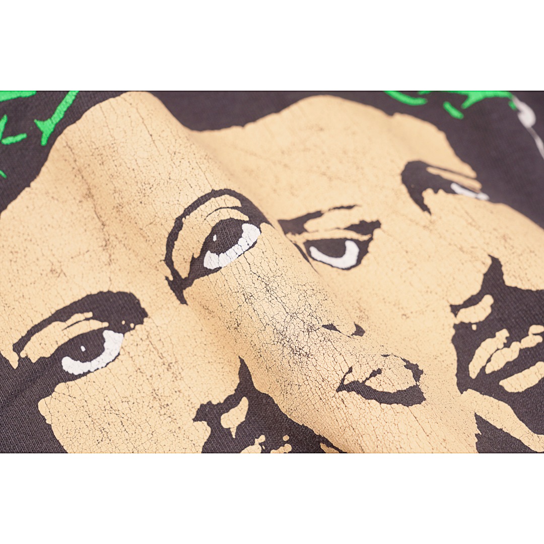 💰170
Saint Michael 黑色三脸男做旧印花短袖T恤
Size：S M L XL

说起 Saint Michael 的幕后主脑，朋友们应该都不算陌生 —— READYMADE 主理人细川雄太，以及他的挚友洛杉矶平面艺术家 Cali Thornhill Dewitt。READYMADE 通过回收军布，重塑各大品牌的经典设计，其独特的想法和过硬品质赢得了世界的关注，而细川雄太在二手市场倒腾的过程中亦萌生了新的想法，重新做一个与 Vintage 相关的品牌，只贩售 Vintage 类的单品，他把这个念头告诉了 Cali，两人一拍即合。Saint Michael在最新的一季作品中依旧延续了浓厚的宗教色彩，这种风格的延续也慢慢的变成了这个品牌的标志性特色，今天这款短袖T恤也依旧如此！面料采用定织筒织16支气流纺，全身独特的龟裂印花做旧工艺让这件短袖看上去有着强烈的年代感，胸口的十字耶稣受难在Saint Michael的作品中也是常客，后背那句硕大的英文标语do not make your time on earth into a cheap joke警示着人们不要把你在地球上的时间变成一个低级的玩笑颇有深度！再来细细品味下这款短袖T恤的其他细节之处：整件衣服经过涂料染后再加上喷砂做旧工艺，复古感十足！双针链条通肩包条以及下摆的古法天地针把一件复古T的细节拉满！只要你喜欢这种复古感觉这款T绝对是你不容错过的一款潮流单品！

款式编号：A-56056056018