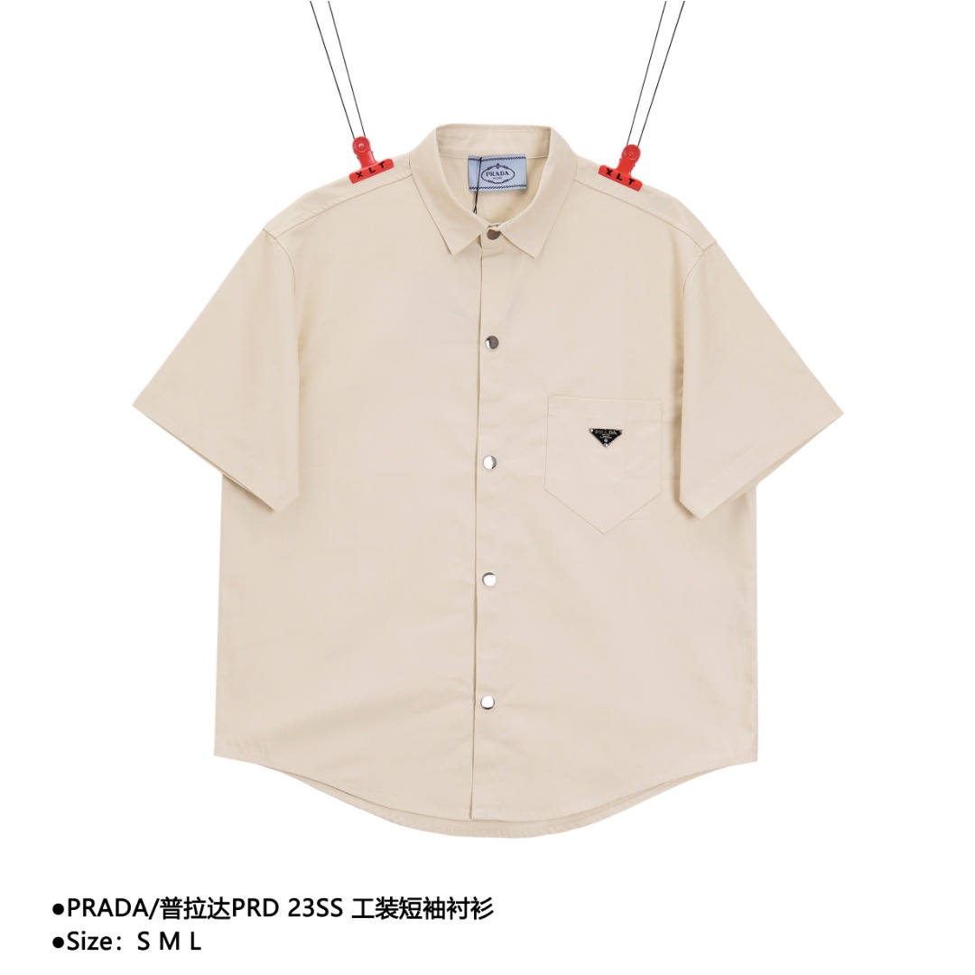 PRADA/普拉达 PRD 23SS 工装短袖衬衫 采用天丝棉斜纹面布,方正剪裁传统衣领,同色间面线贴布口袋.口袋打枣工艺,涂珐琅金属三角形徽标点缀,直筒剪裁. 款式编号:A-560565602322