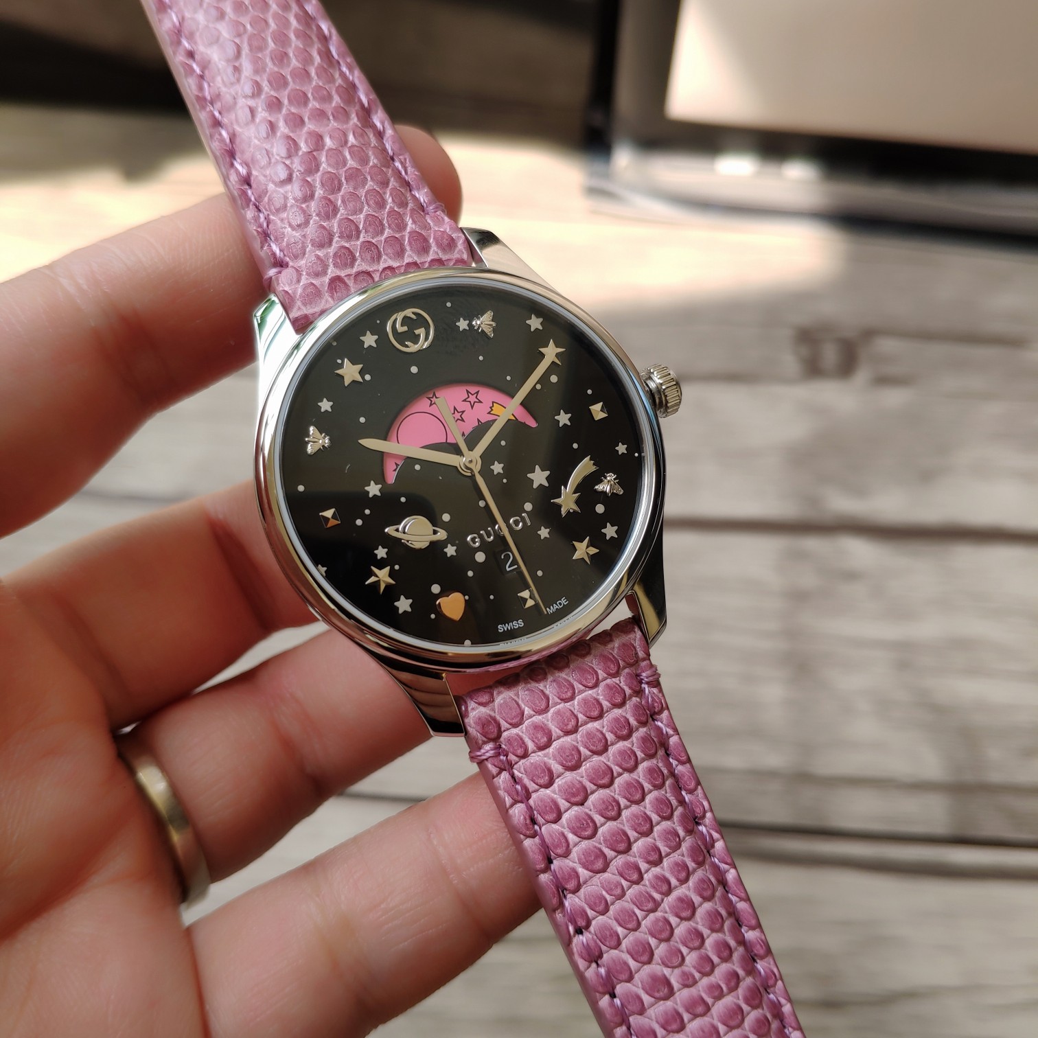 NO:388338,Gucci Gucci counter latest moon phase quartz women's watch, 36mm polished stainless steel thin case, paired with interlocking G crown, black painted dial, paired with silver stars and planet patterns, Gucci scale interlocking G, bees, stars, rivets and rose gold heart shape, as well as pink and colorful moon phase disc, paired with golden comet pattern, snap-buckle bottom cover, matched with bee carving, lizard leather strap with stainless steel pin buckle, original Swiss Ronda quartz moon camera movement, sapphire crystal, with anti-reflective coating, waterproof level up to 5 ATM (foot/50 meters) 2-year warranty, equipped with original box!  ,gucci,gucci19860909古驰 Gucci专柜最新月相石英女表,36毫米抛光不锈钢薄表壳,搭配interlocking G表冠,黑色涂漆效果的表盘,配以银色星星和星球图案,Gucci刻度interlocking G、蜜蜂、星星、铆钉和玫瑰金色心形,以及粉色、彩色月相盘,搭配金黄色彗星图案,按扣底盖,配以蜜蜂雕花,蜥蜴皮表带配以不锈钢针式带扣,原装瑞士朗达石英月相机芯,蓝宝石色水晶,配以防反光涂层,防水级别达到5 ATM（英尺/50米）2年质保,配原盒！,,gucci,gucci,Watch