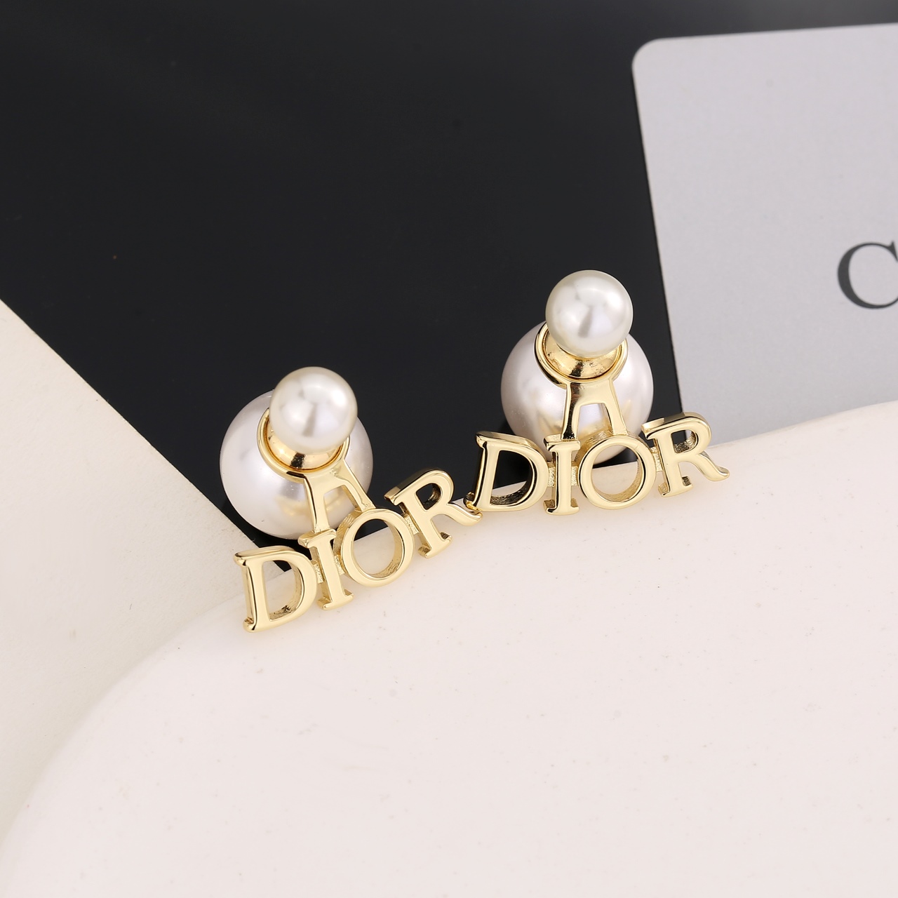  迪奥字母cd珍珠耳环  这款 Dior Tribales 耳环在 Dior 标志性款式的基础上演绎出新