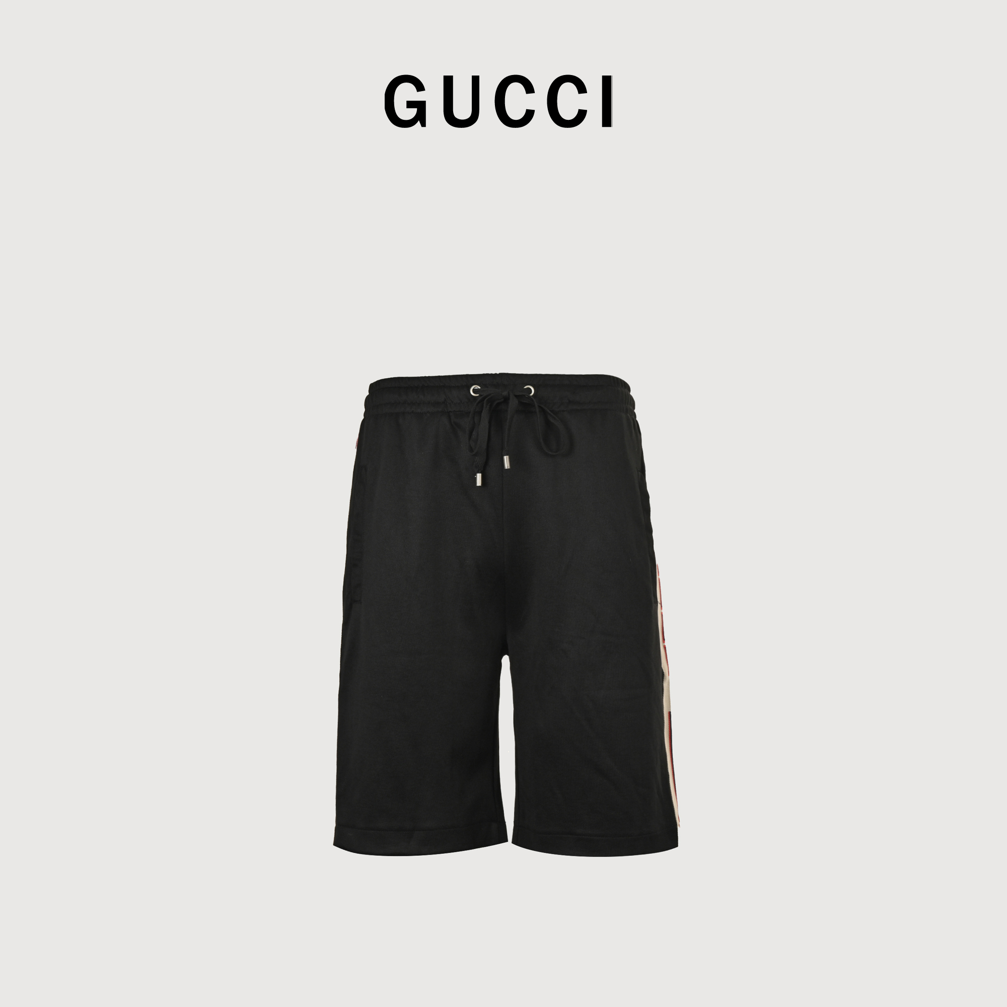 Gucci/古驰 经典织带短裤 第一时间5900购入zp开版,潮流瞬息万变,经典永不过时.此款为旧款经典无扣校服款式,无扣款式对比侧边有扣款式又具有夏天运动性.面料是涤棉提花布,运动功能面料,主面料订织丝盖棉布料,侧边为定织暗米色织带,织带密度和Logo位置同步ZP,区别市面白色现成织带,全套定制辅料,主唛洗唛定制,裤子内侧做腰头包边,口袋包边,口袋后侧做烫衬防止口袋破损变形(别人真的没法比)五金吊钟开模钢印Logo清晰,裤绳吊钟为上旋螺丝非快餐版本细线穿洞.